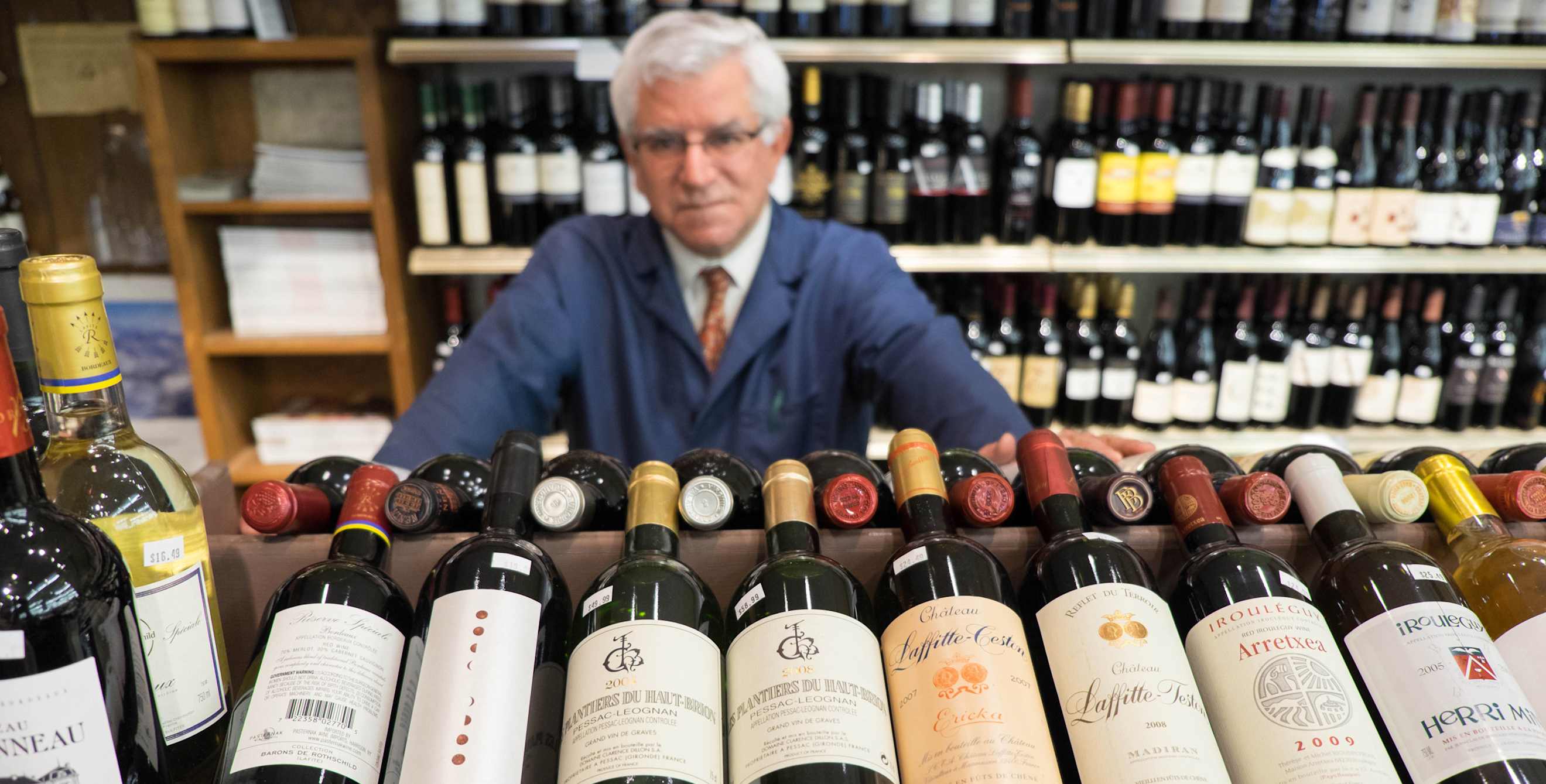 Darrell Corti with bottles of wine at Corti Bros in Sacramento, image