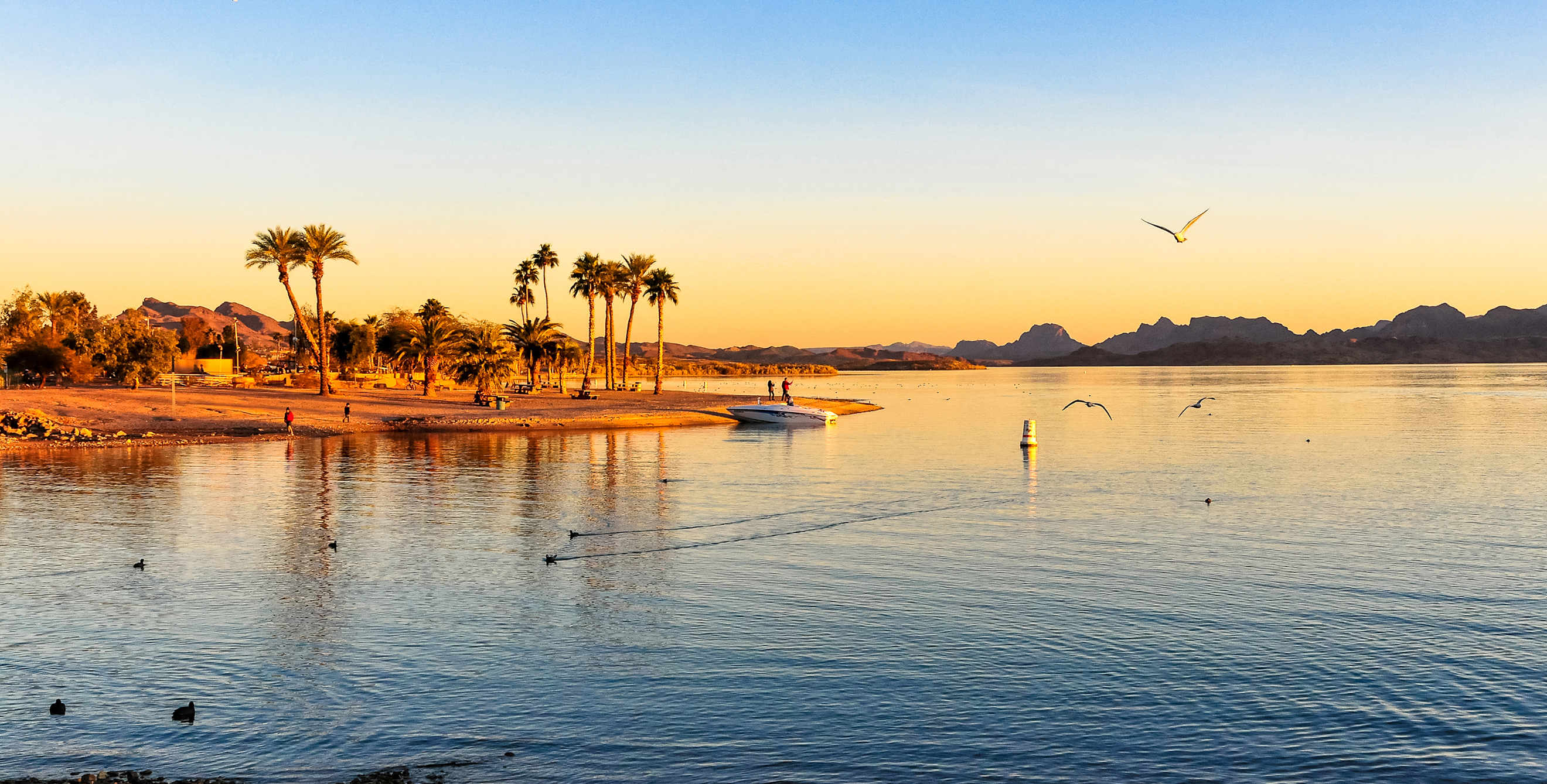 A boat on the beach at Lake Havasu, Arizona at sunset.