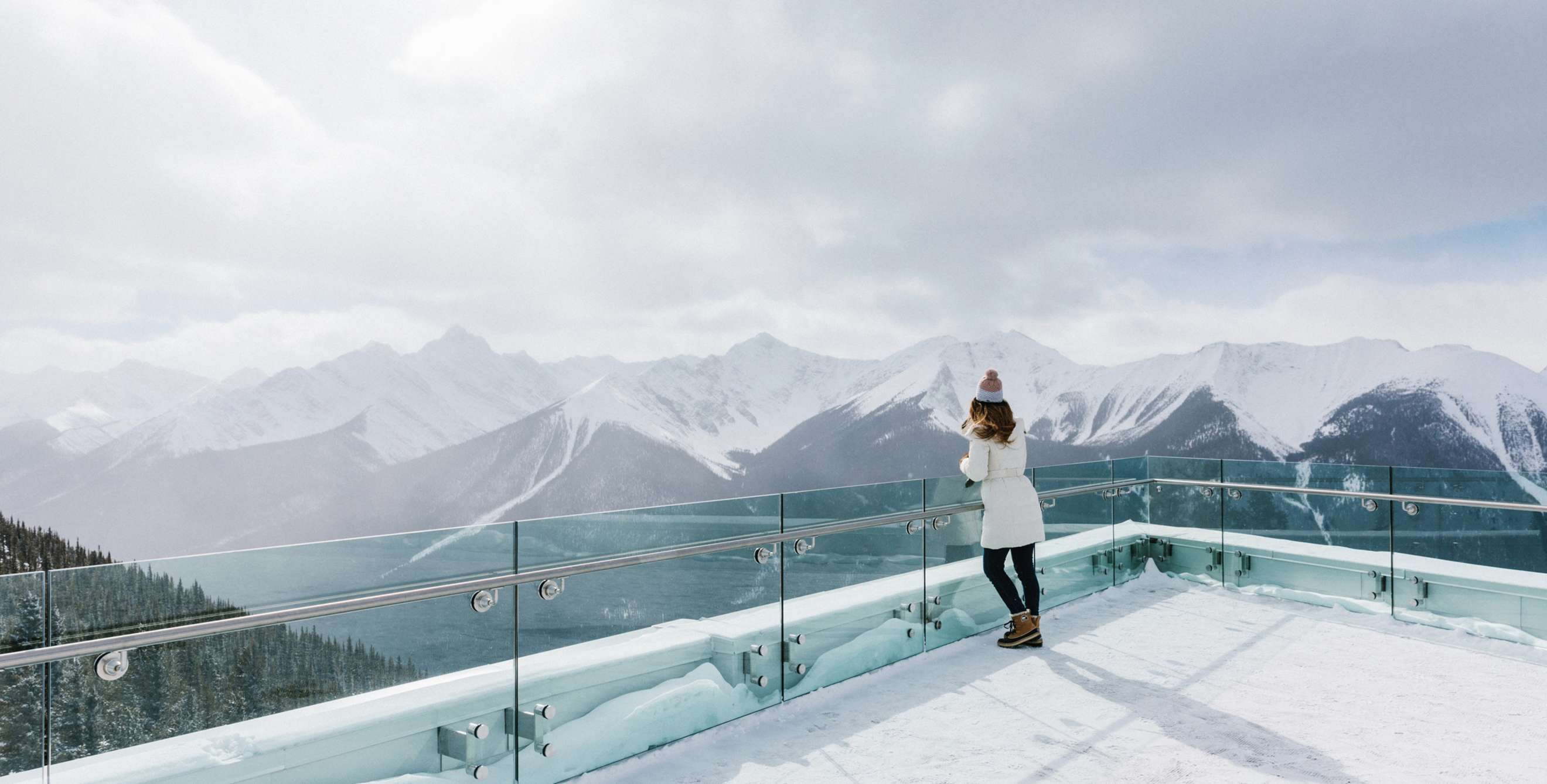 visitor takes in panoramic, view of snow-capped Canadian Rockies from Sulphur Mountain at Banff in Alberta, picture