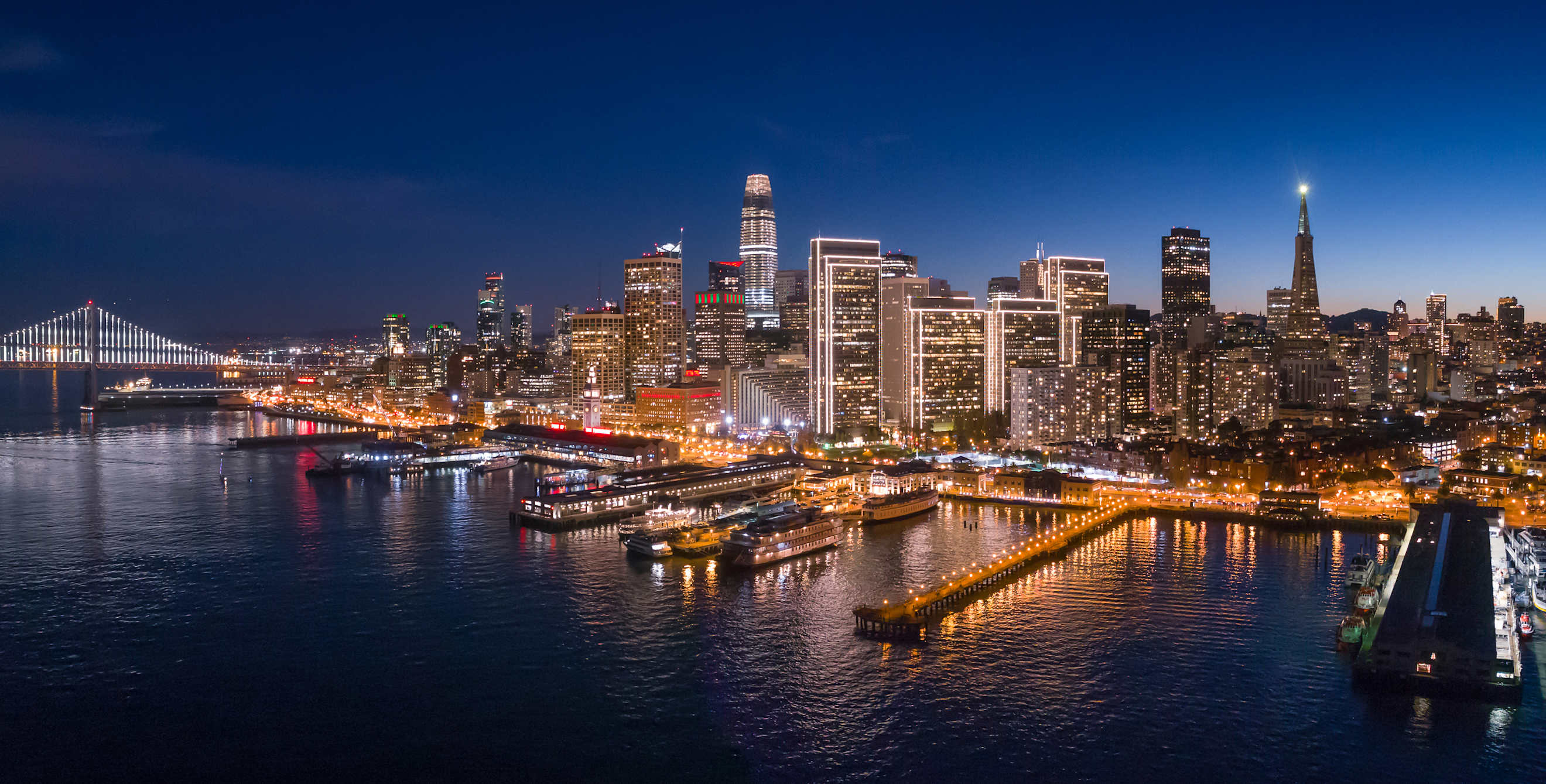 The San Francisco skyline and lights reflect off the San Francisco Bay at Dusk, image