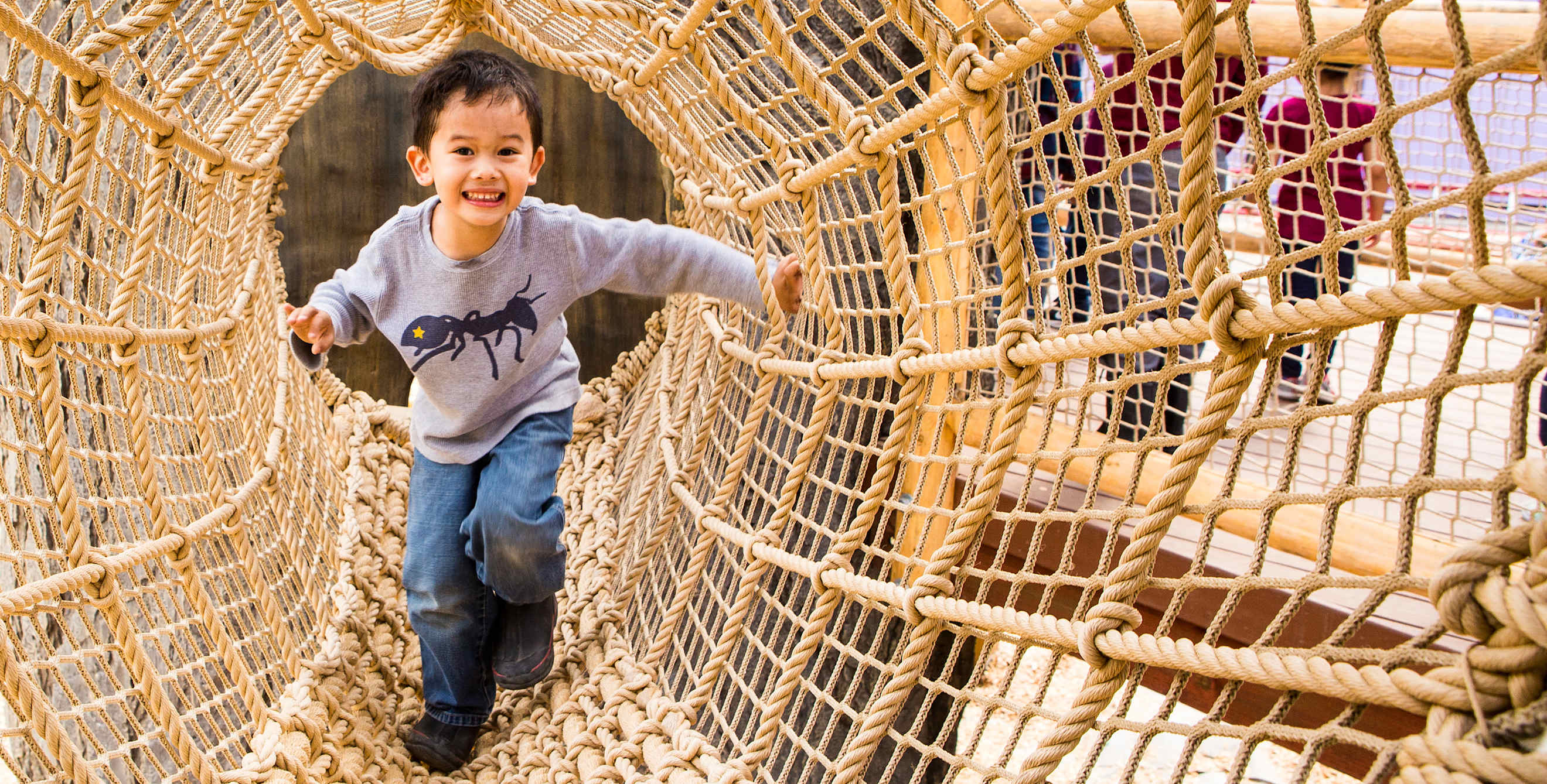 a child plays on a rope exhibit at Bill's Backyard at the Children's Discovery Museum in San Jose, California