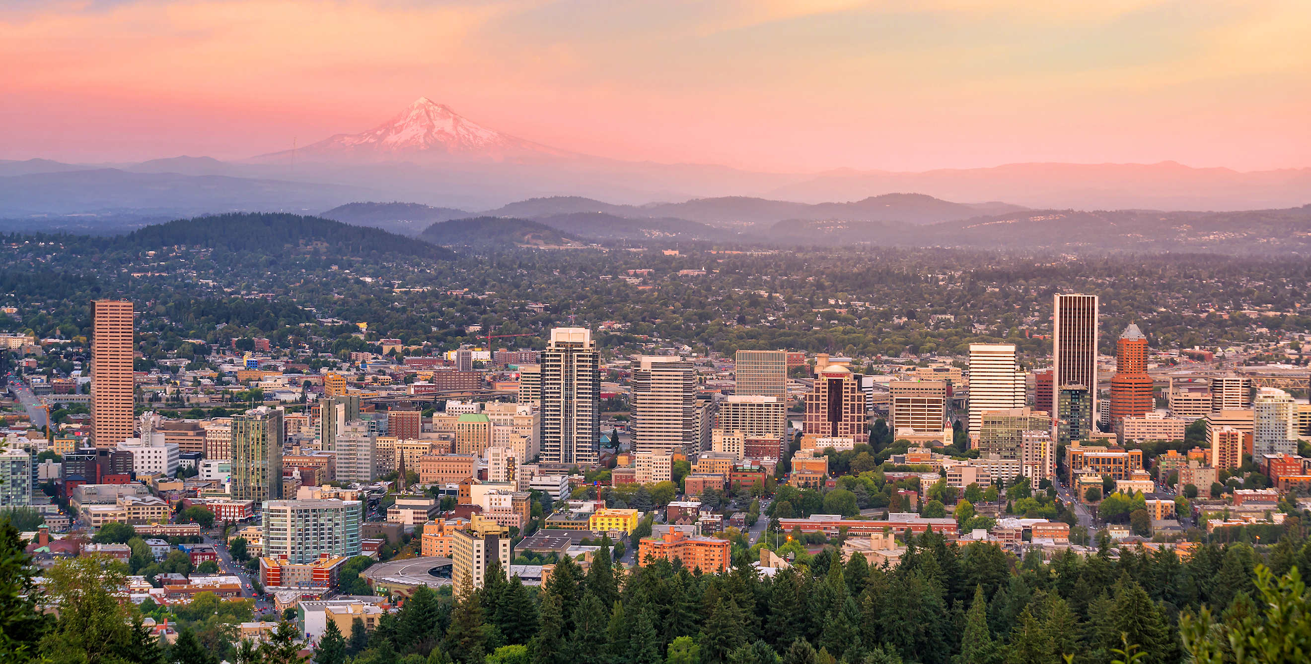 Portland, Oregon skyline stretches from downtown to Mount Hood in the distance at sunset, image