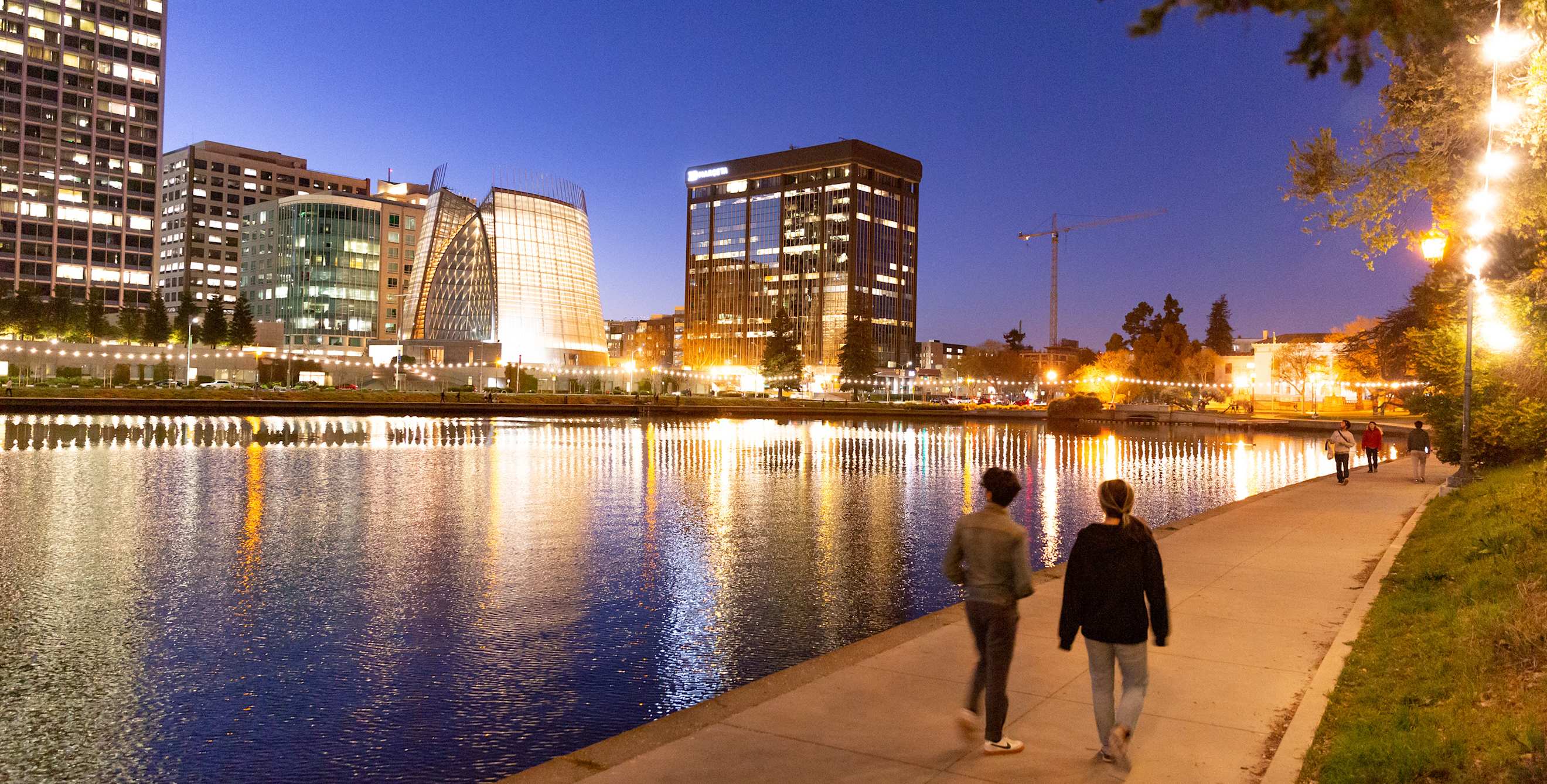 The Cathedral of Christ the Light reflects across Oakland's Lake Merritt at night, image