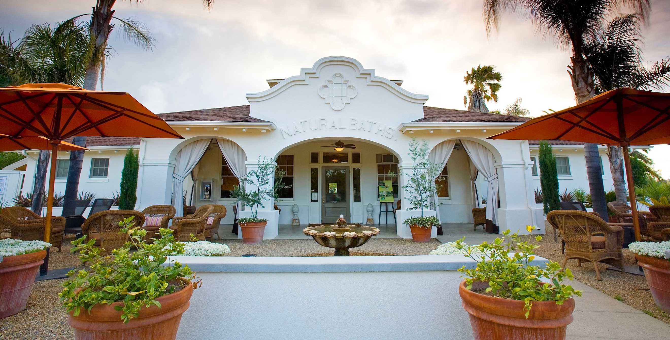 Indian Springs spa courtyard with rattan chairs, umbrellas, and palms trees in Calistoga, California, picture