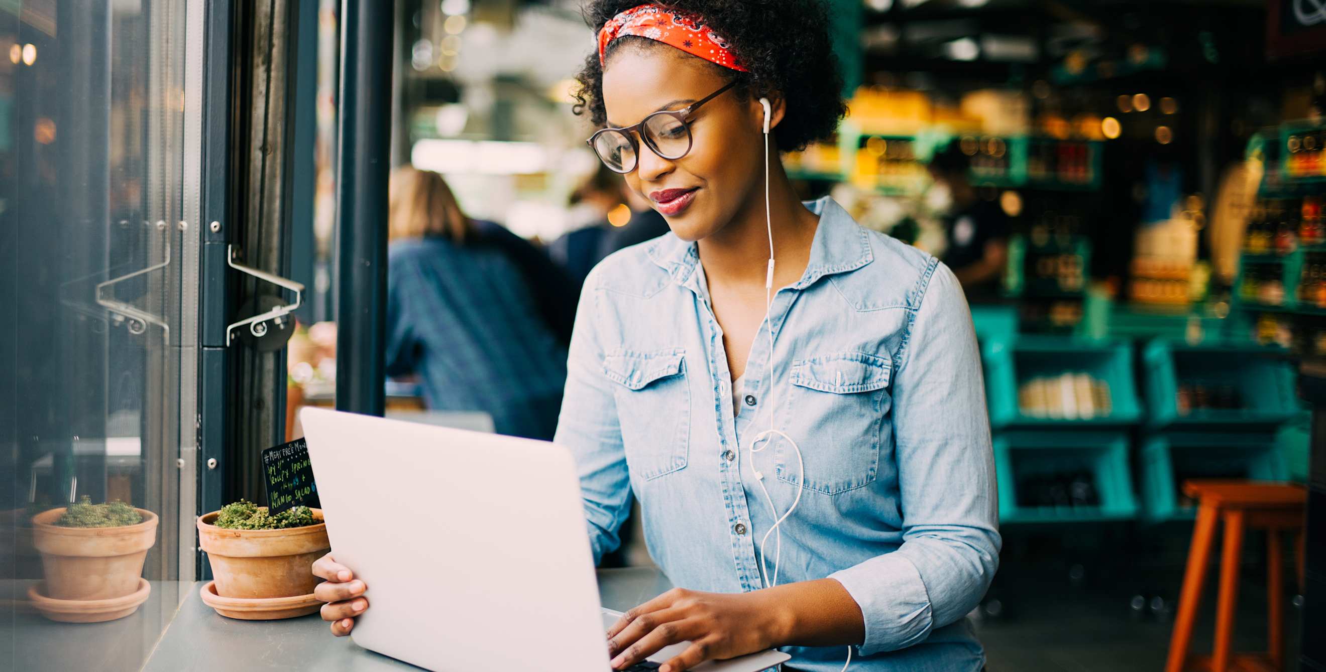 A woman works on her computer in a coffee shop