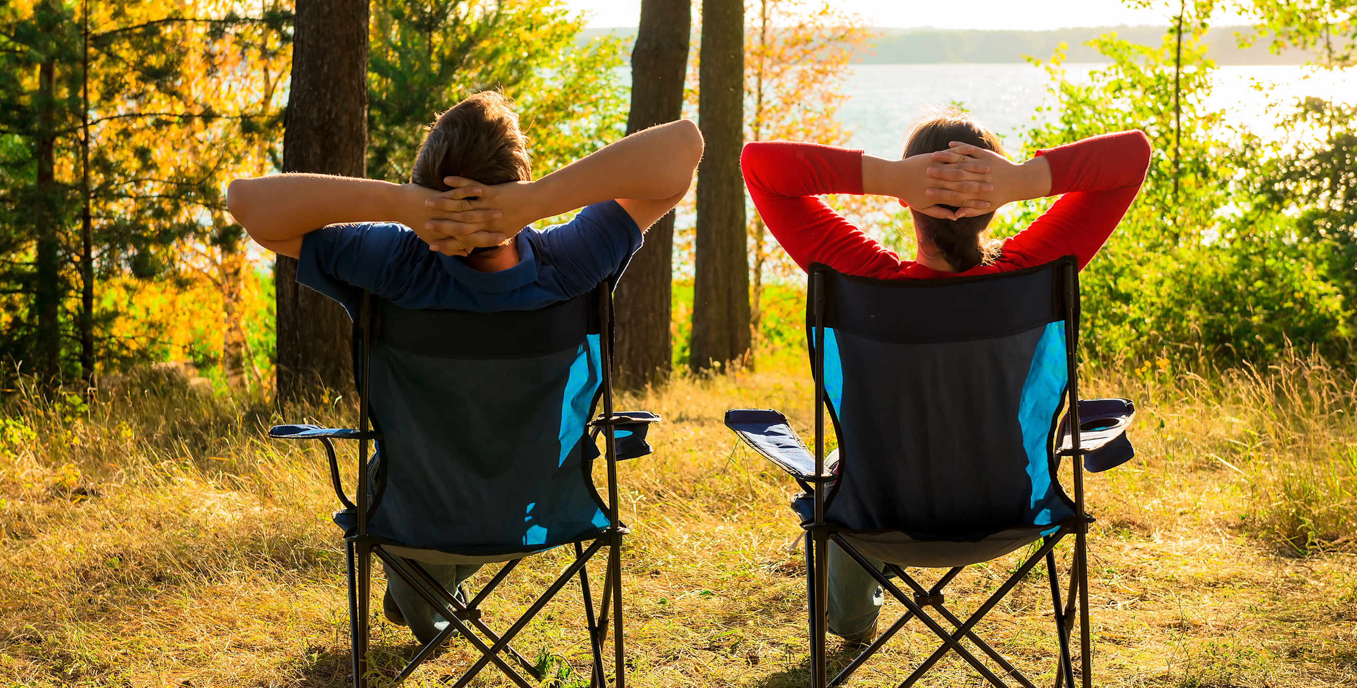 man and woman enjoy the view of a lake while camping, picture
