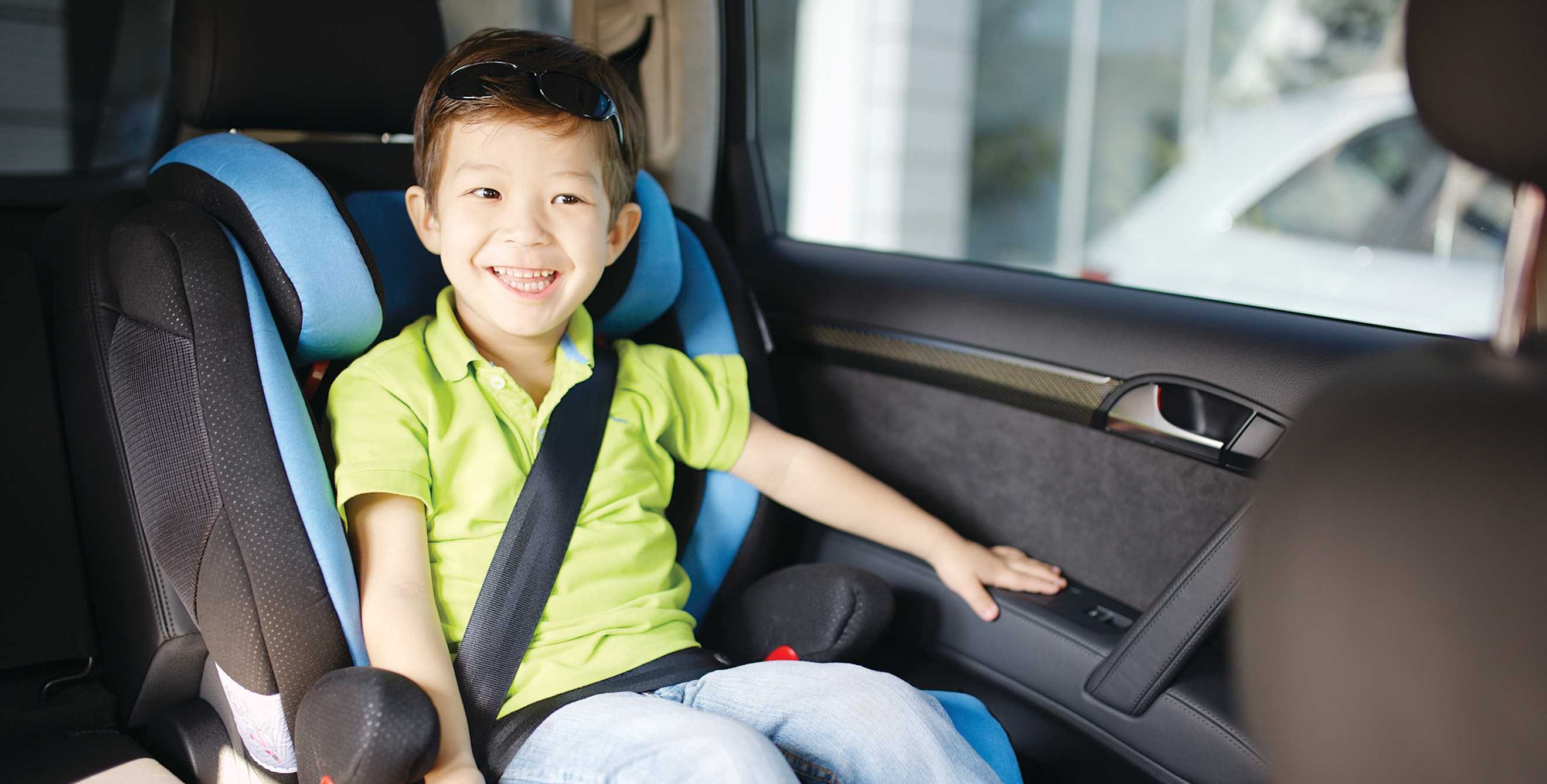 A child sitting in a booster seat with the seat belt properly fastened