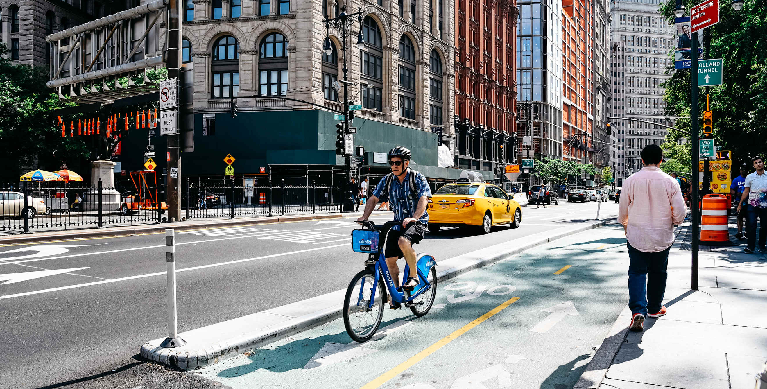 A man rides a shared bike on a protected bike lane in New York City