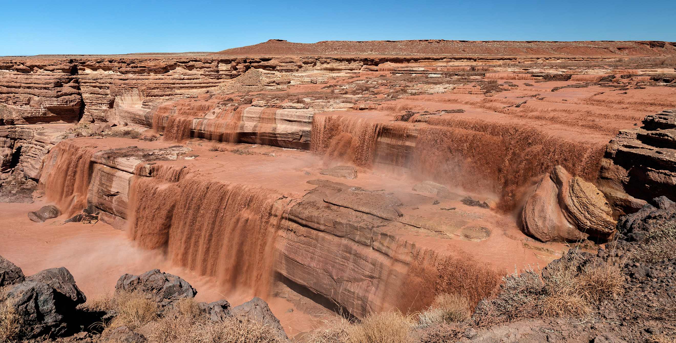 muddy water pours over Chocolate Falls, image