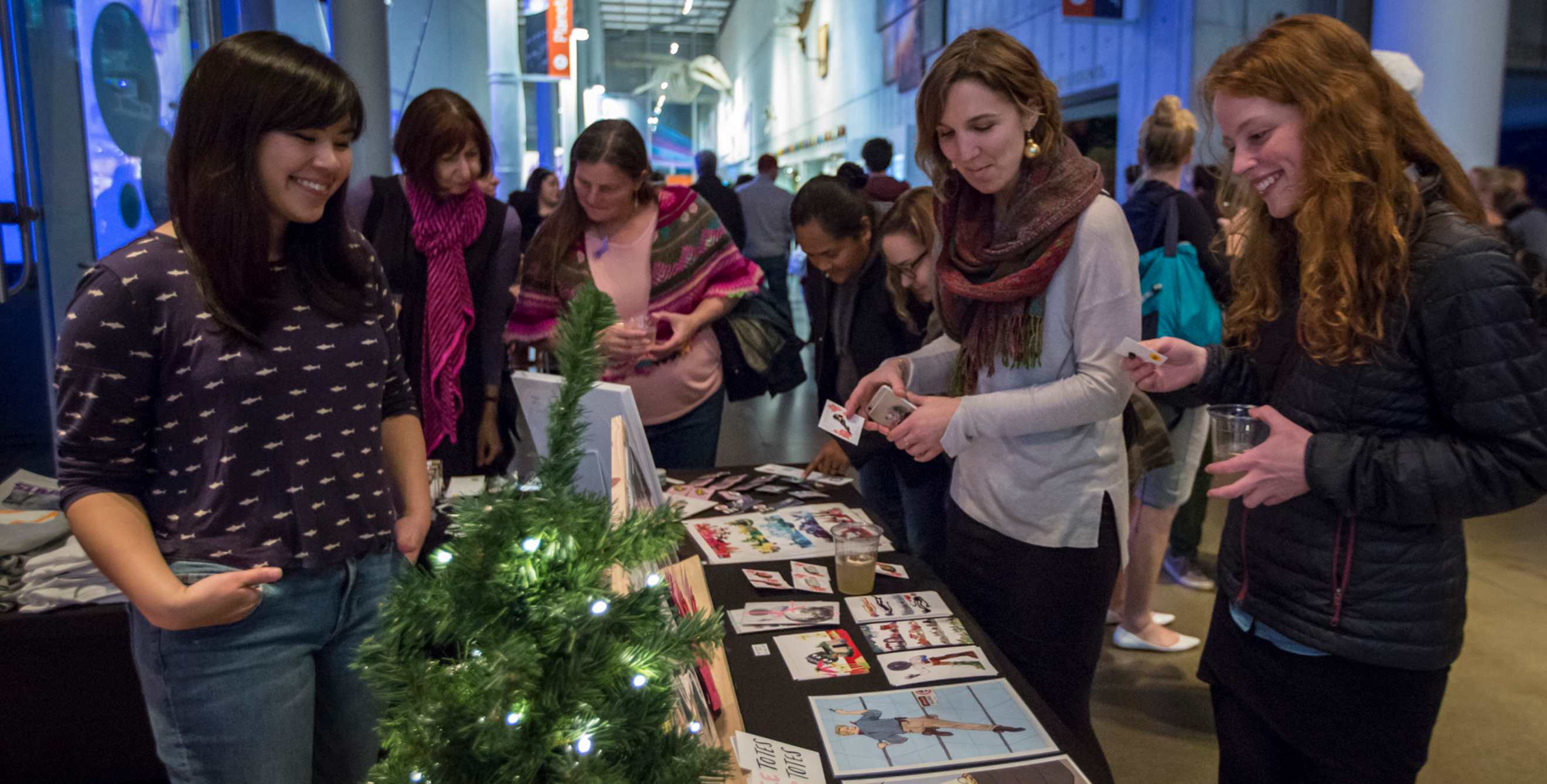Guests at the California Academy of Science's NightLife Holiday Bazaar event look at a vendor's wares