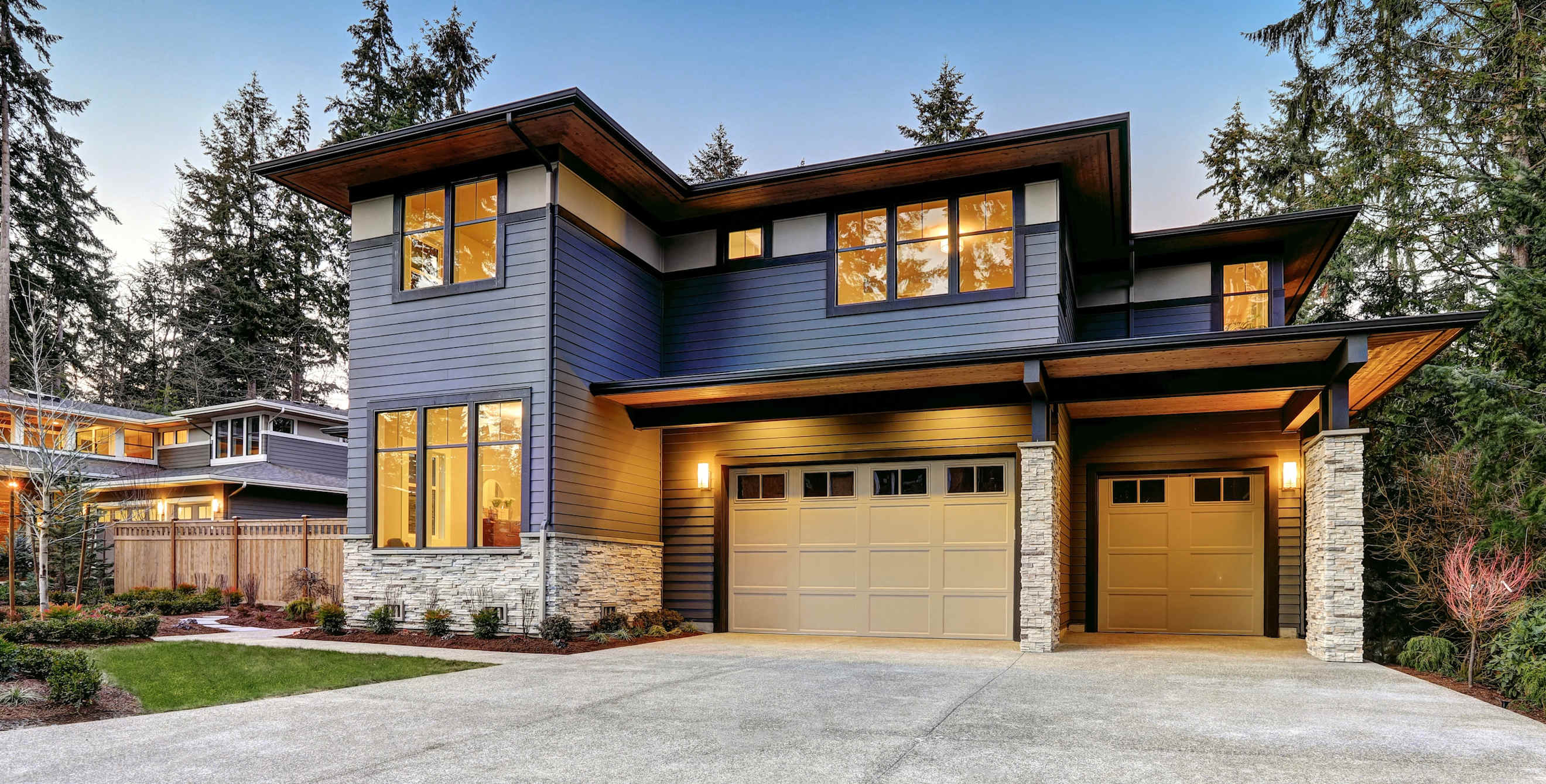 a contemporary, two-story house lit up at night