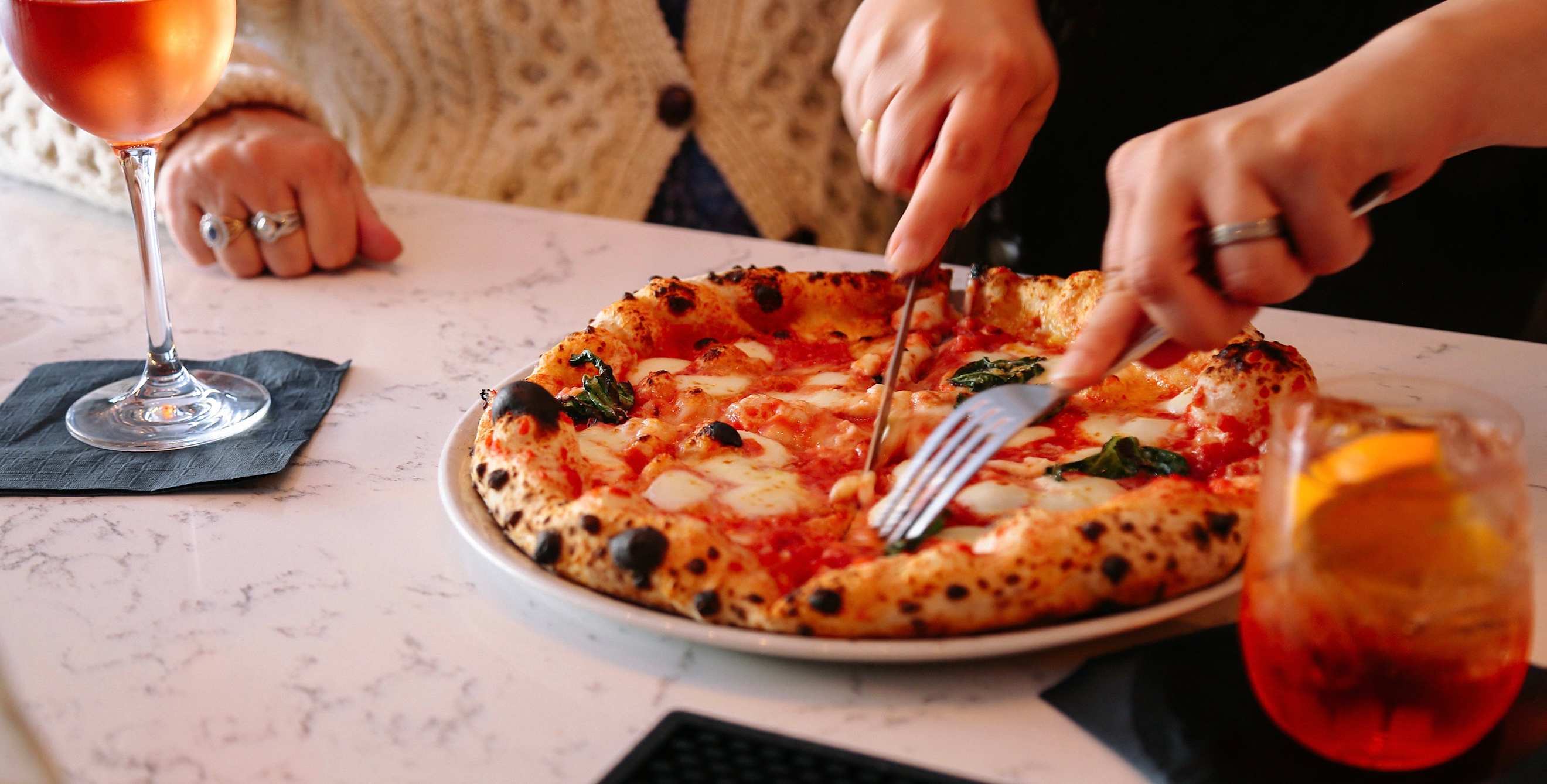 picture of someone cutting into the margarita pizza at Flour House SLO