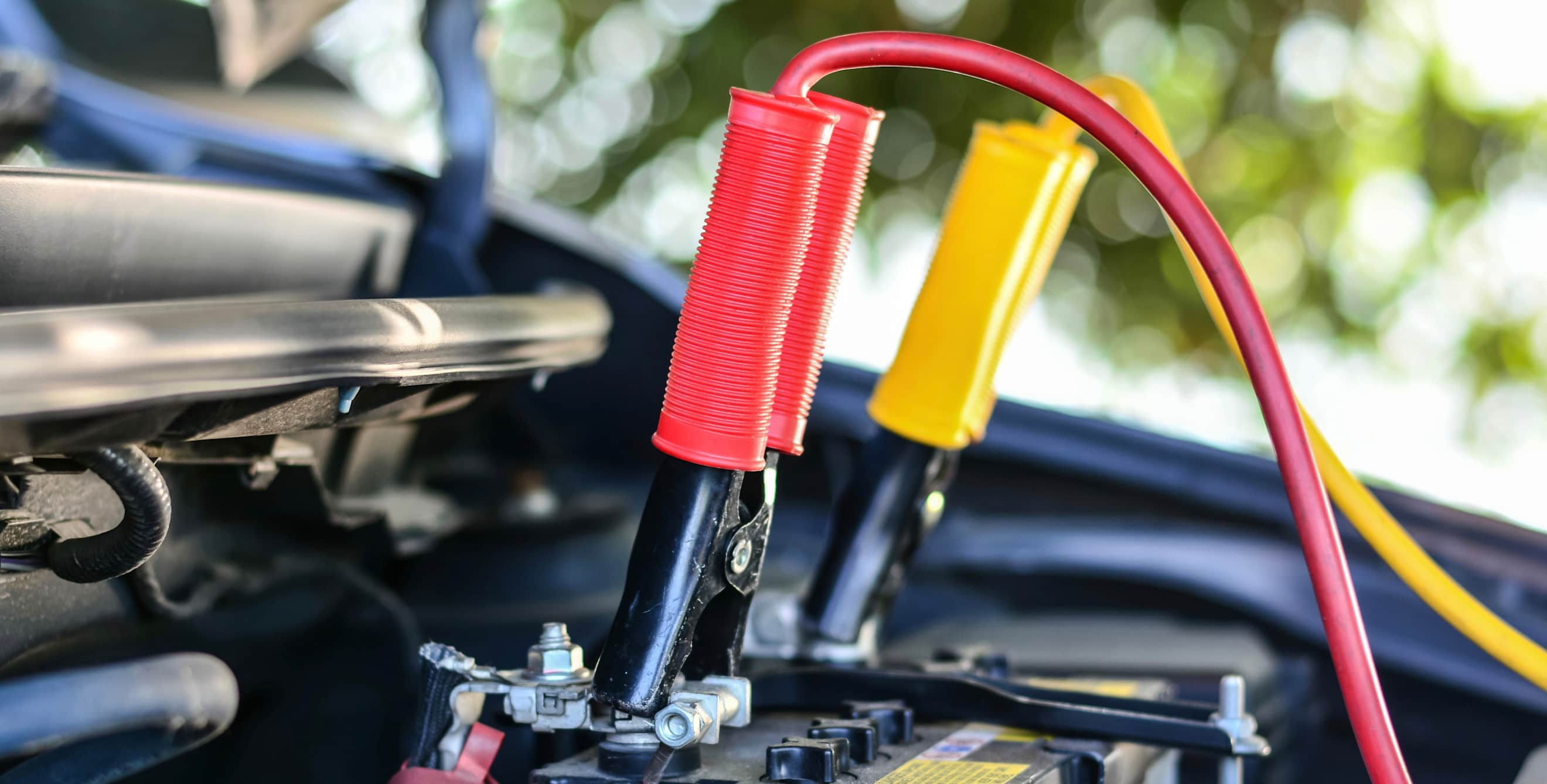car battery with jumper cables attached
