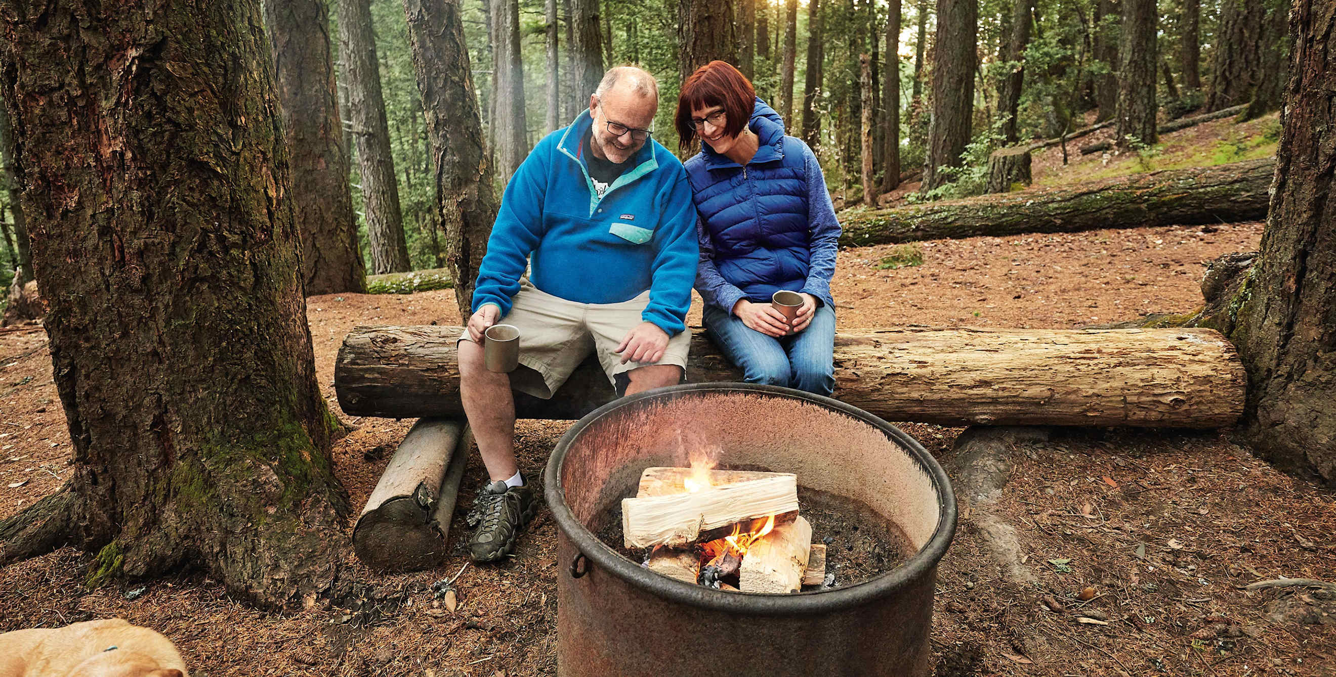 Peter and Nancy Fish, surrounded by redwoods, cozy up by their campsite fire pit in late afternoon at Pantoll campground at California's Mount Tamalpais, picture