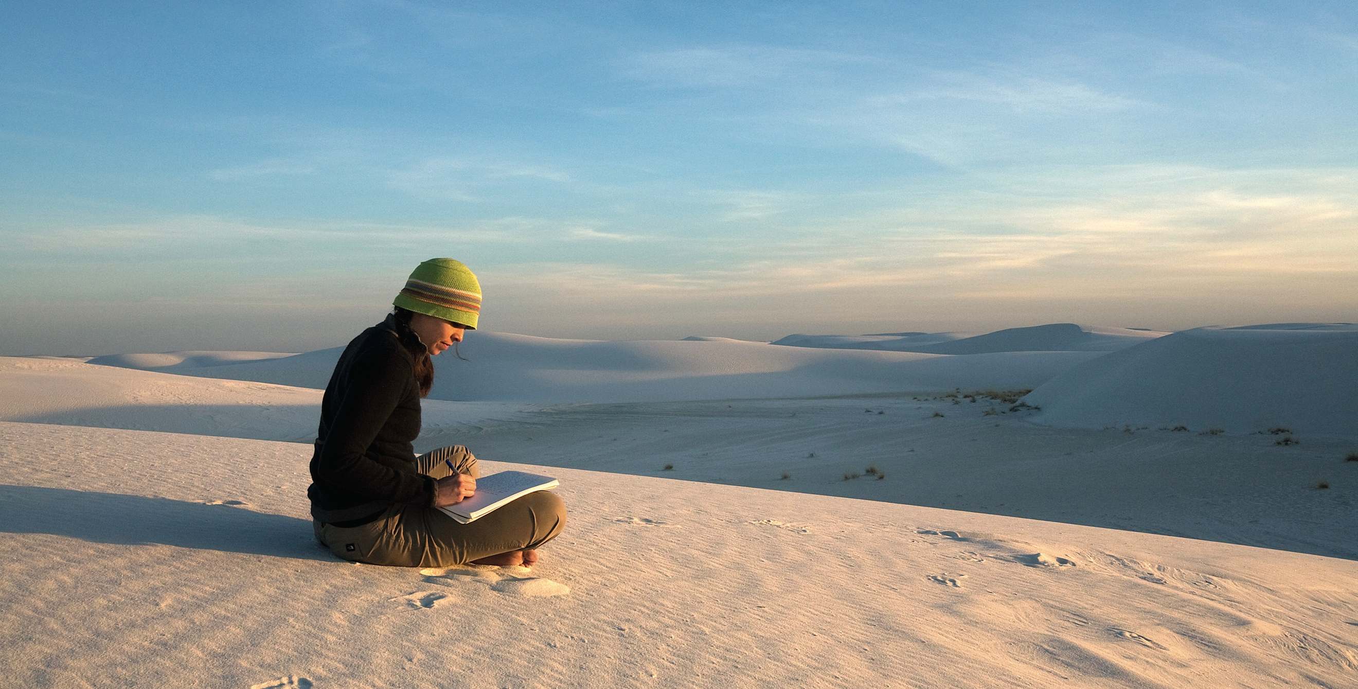woman sitting on ground sketching at White Sand Dunes National Monument, New Mexico, picture