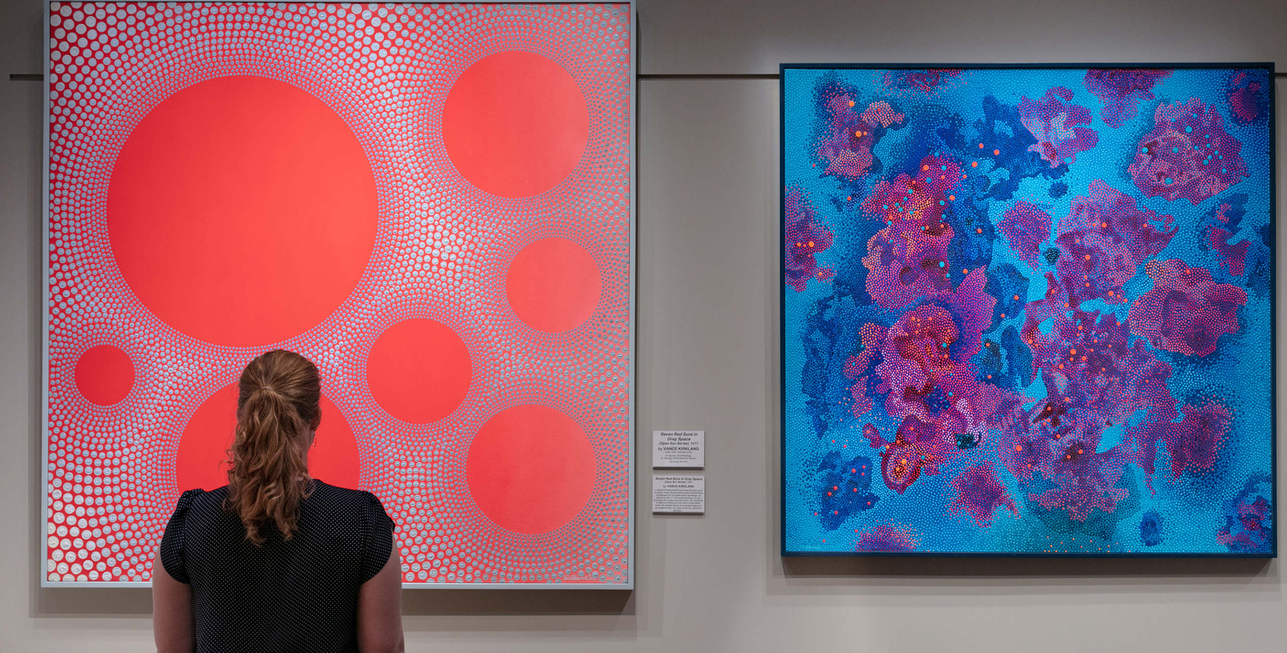 gallery visitor views two paintings by Vance Kirkland at the Kirkland Museum of Fine & Decorative Art in Denver, Colorado