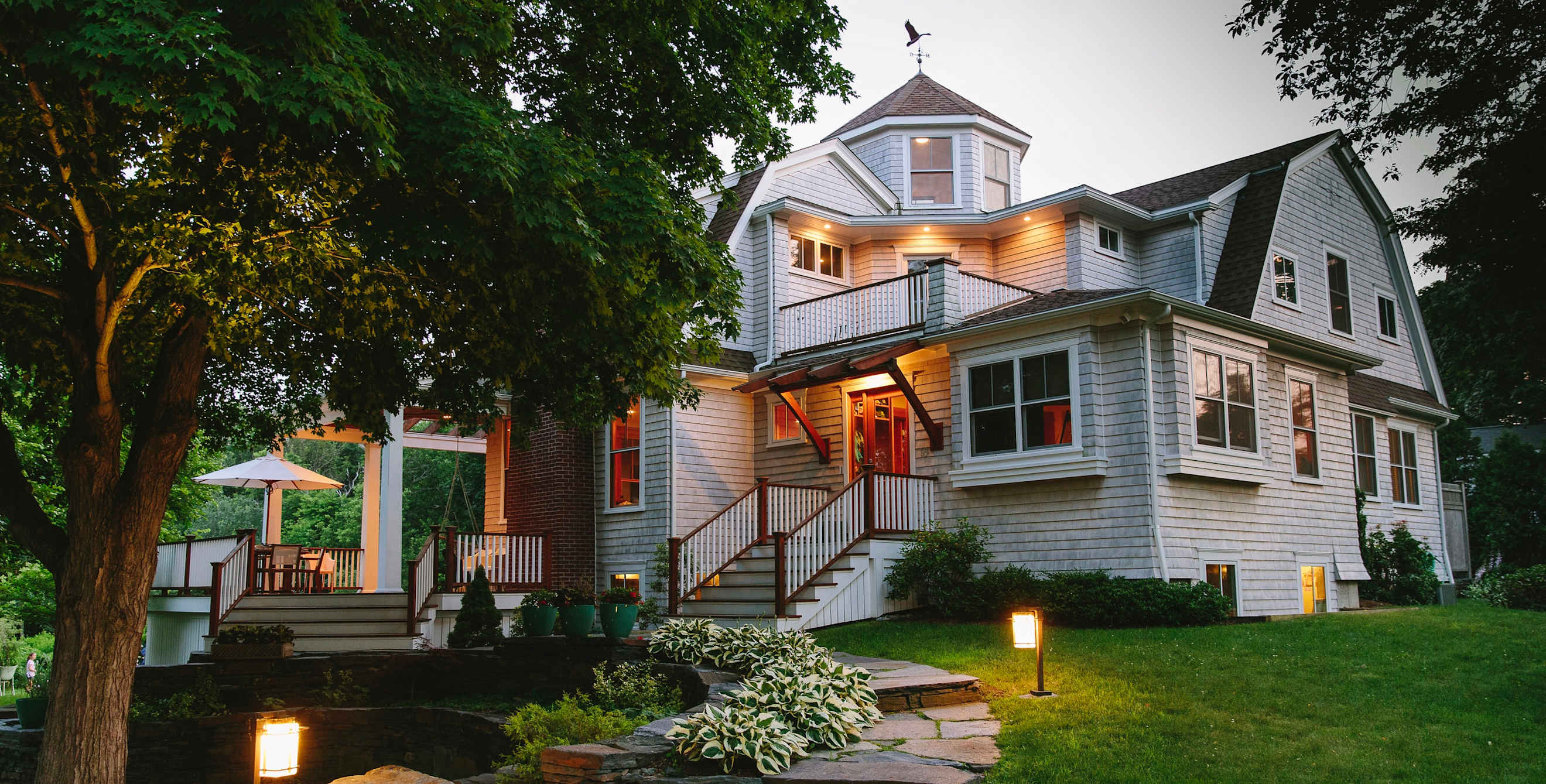 shingled house exterior with exterior and interior security lights on