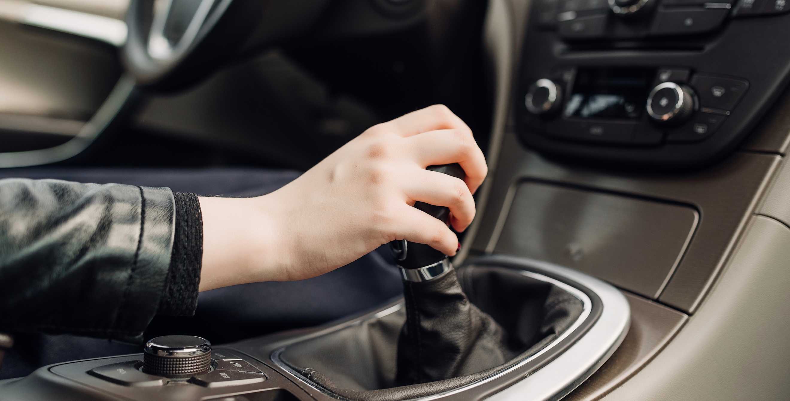 a woman's hand clutches a gearshift in a car