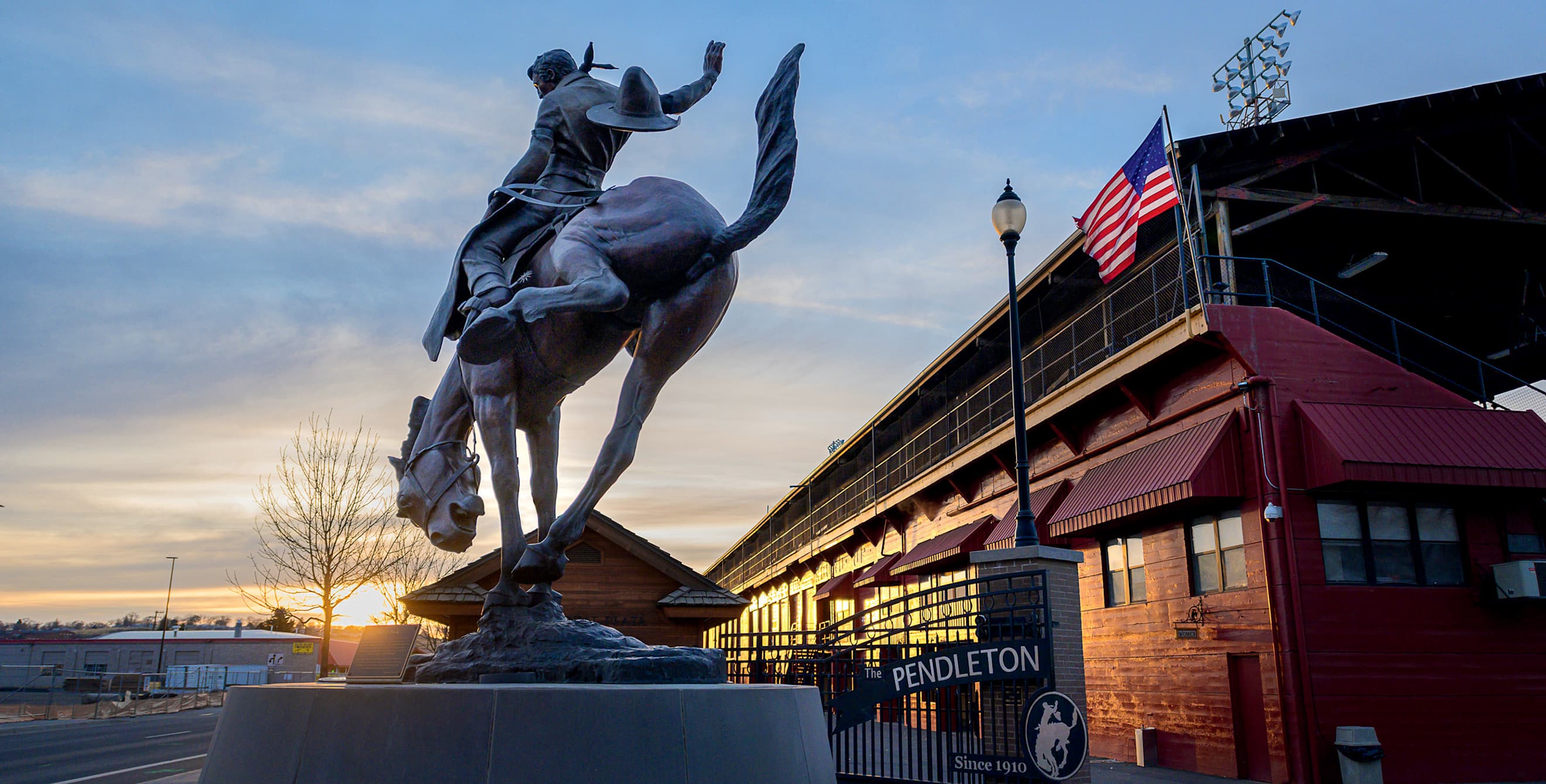 Let 'Er Buck statue at entrance to Pendleton Round-Up rodeo grounds at sunset in Pendelton, Oregon
