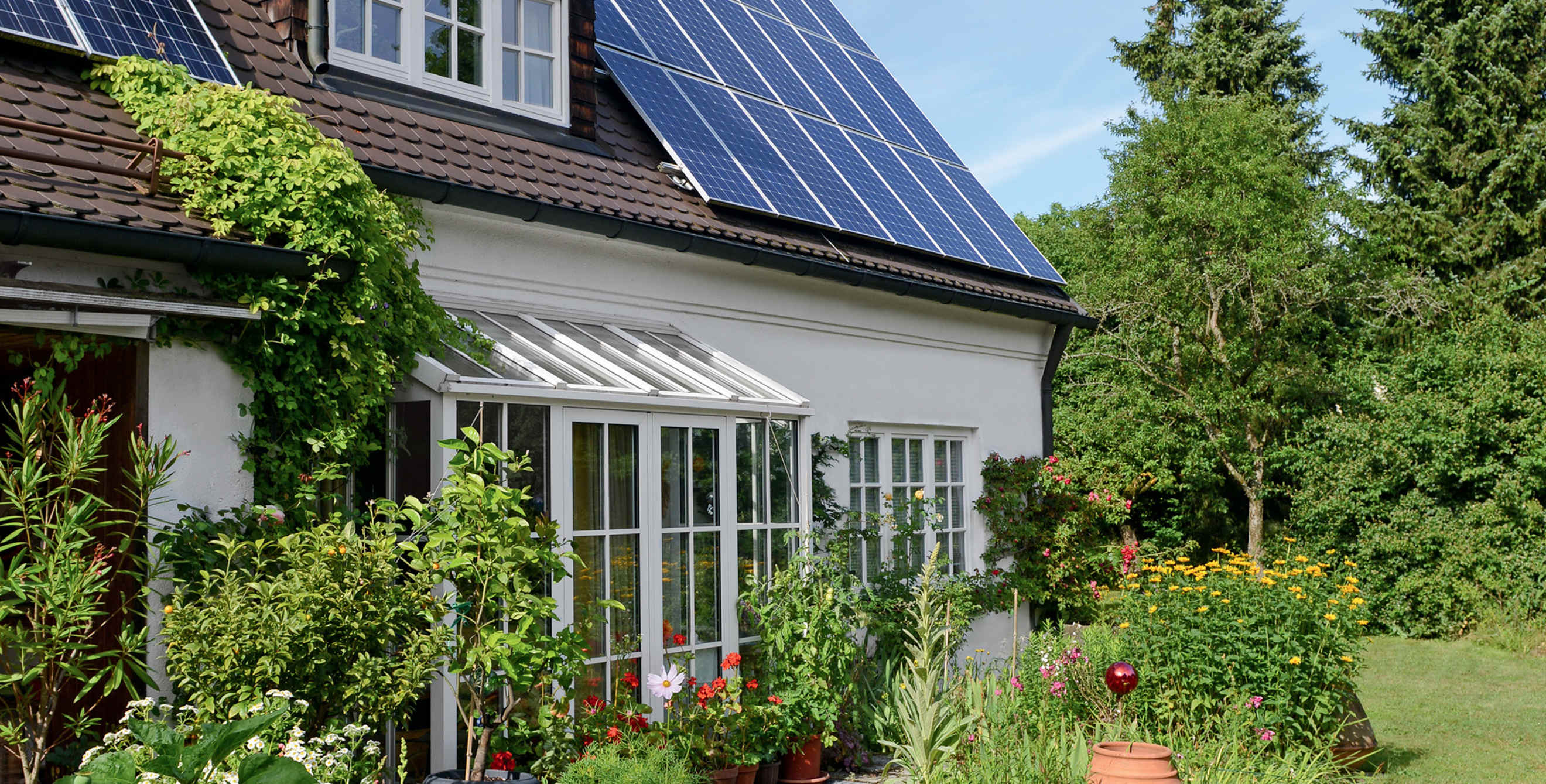 Older frame house with solar panels and garden