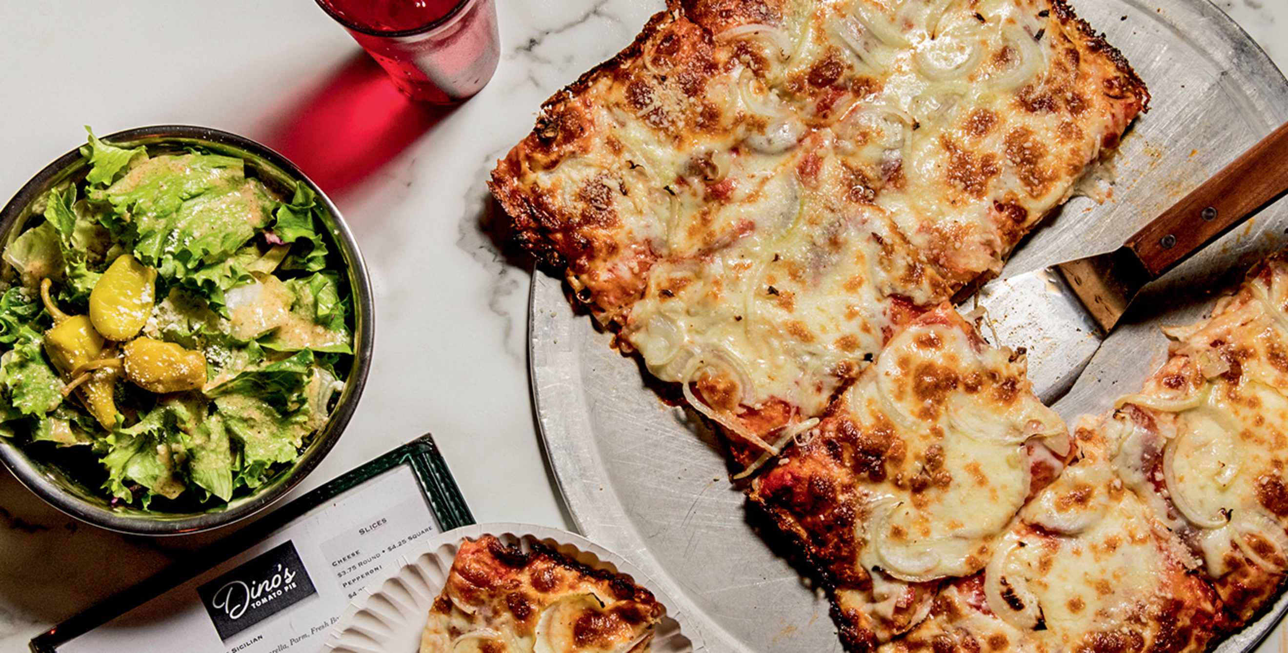 Square pizza with salad at Dino's Tomato Pie in Seattle, Washington