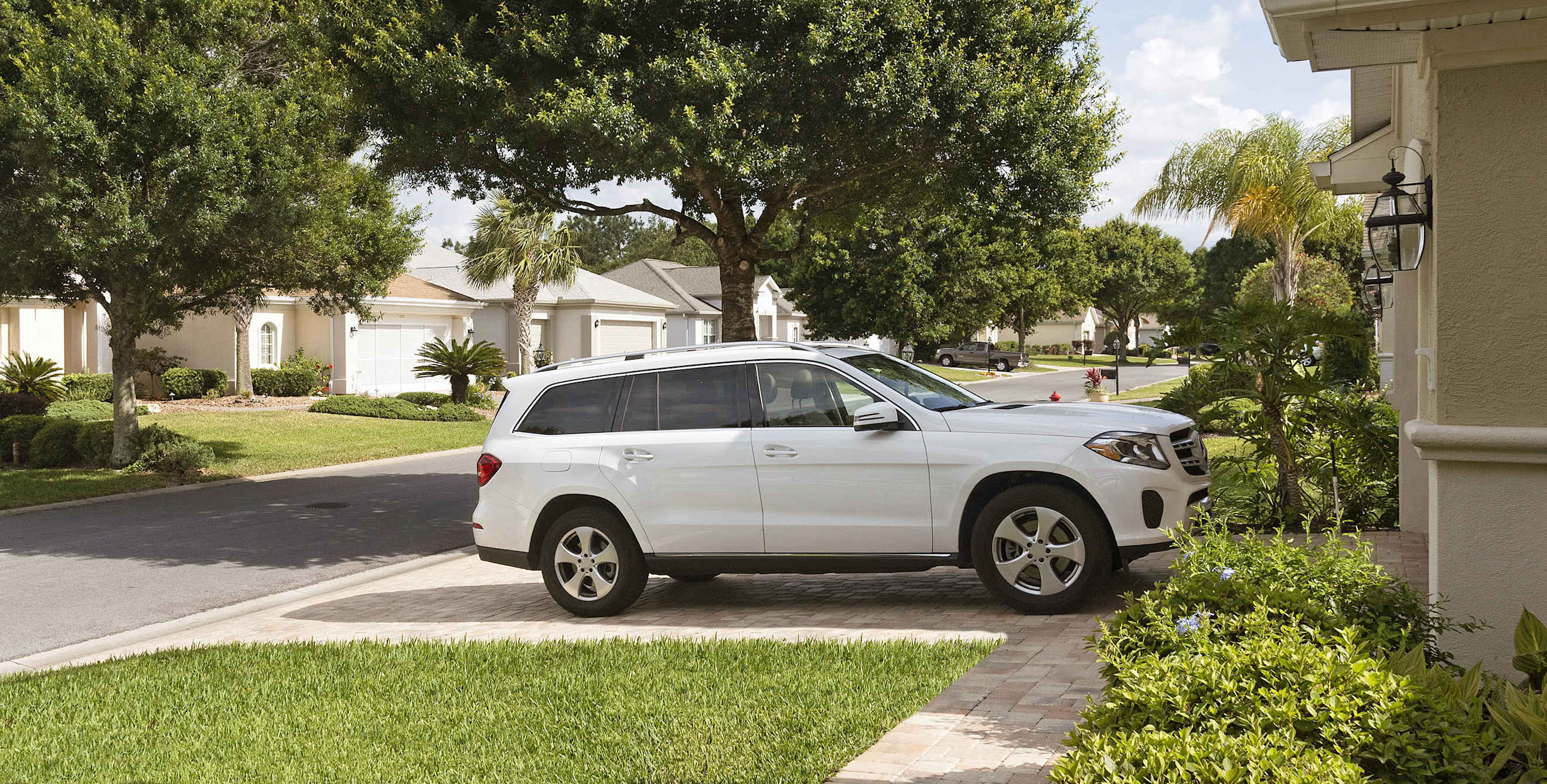 A white car parked in the driveway of a AAA Member