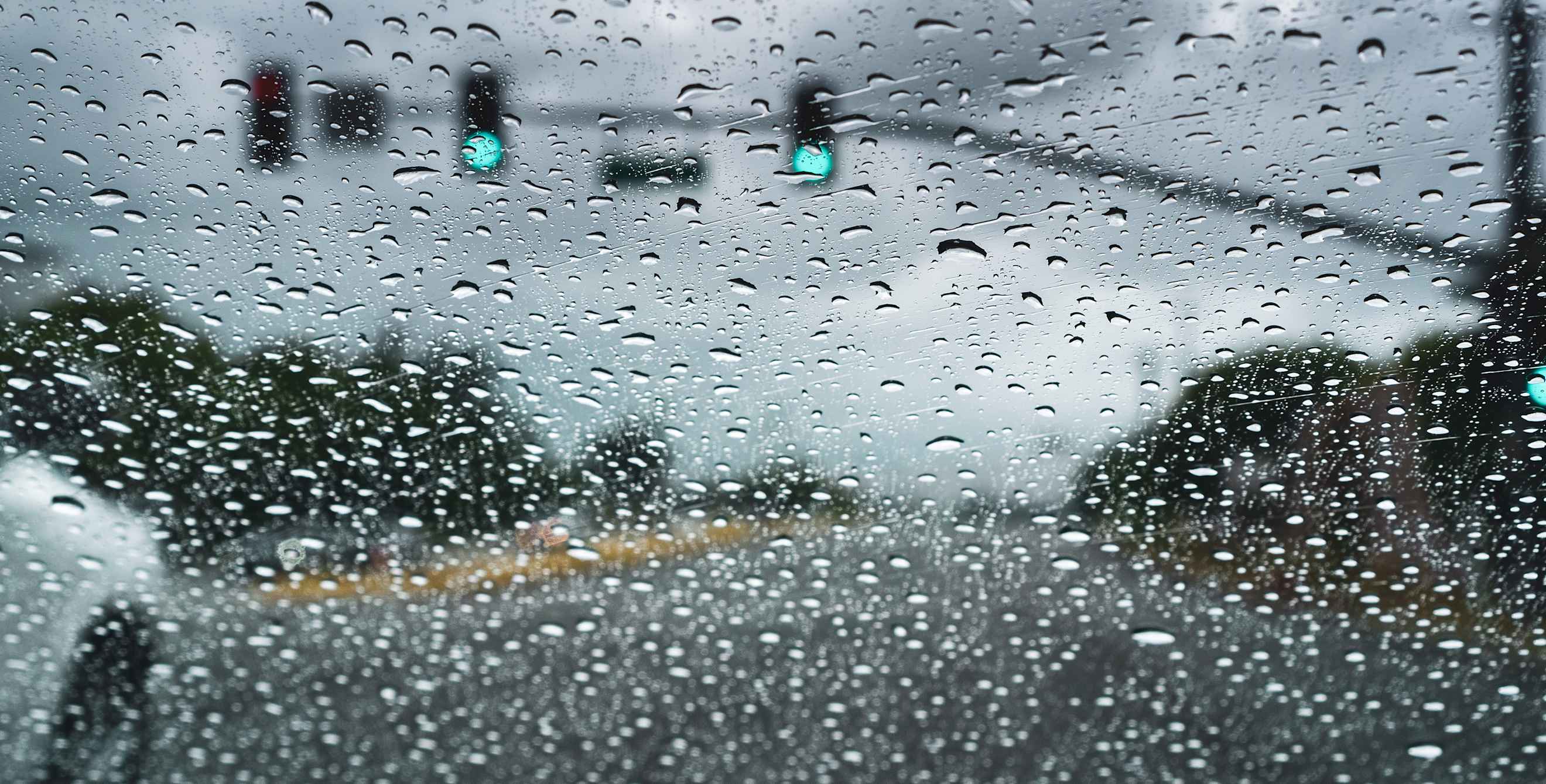 A car drives through the rain.