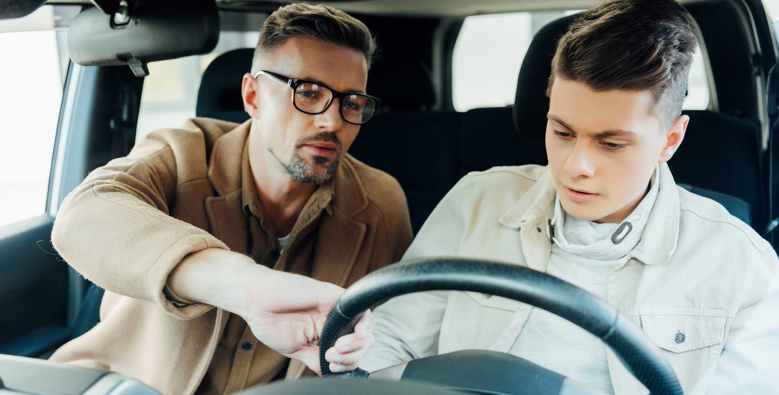 A dad and his son shop for a car.