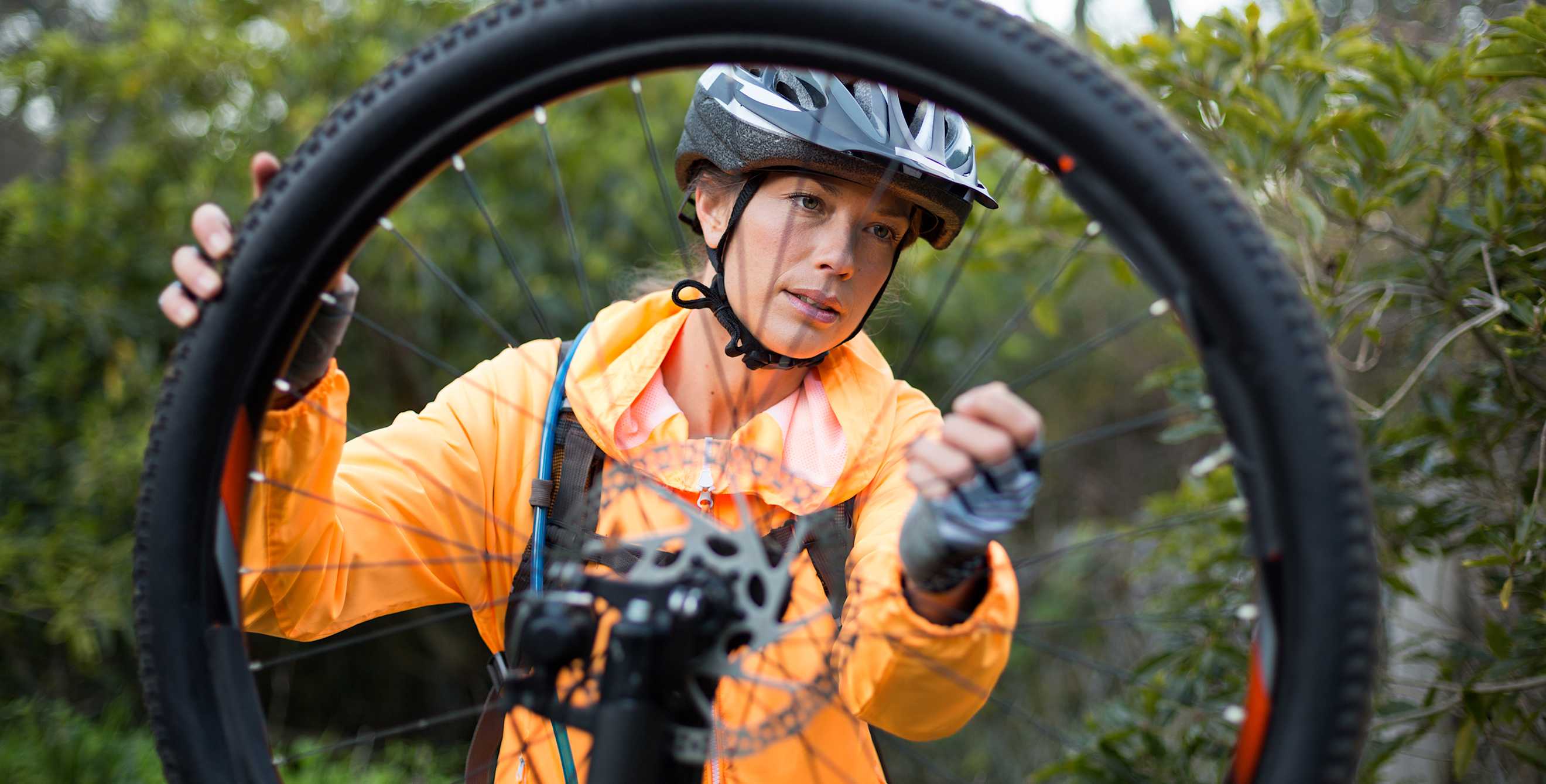 Mountain biker checks tire pressure.