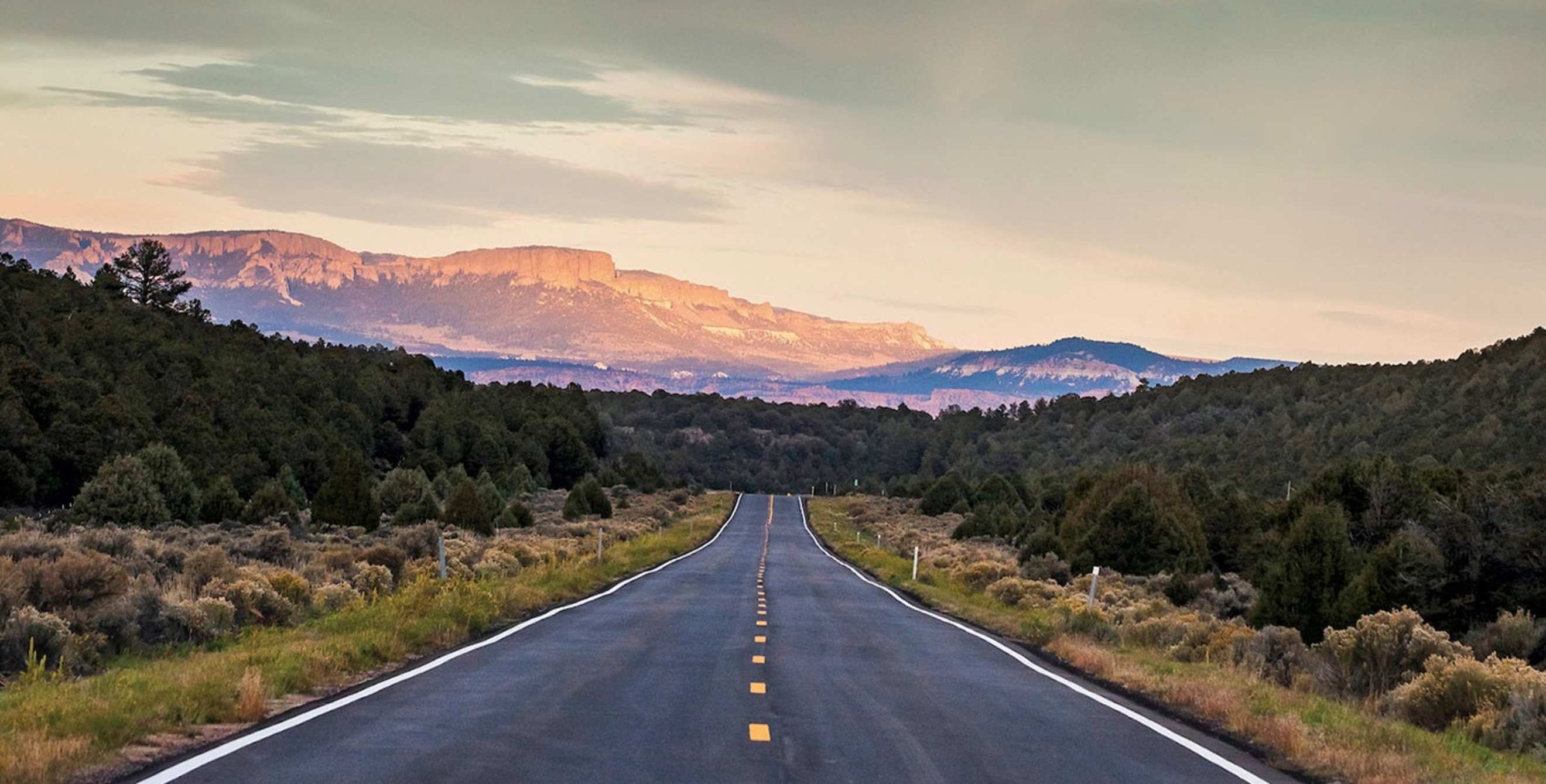 Scenic State Route 143 in Utah with mountains and clouds in the background