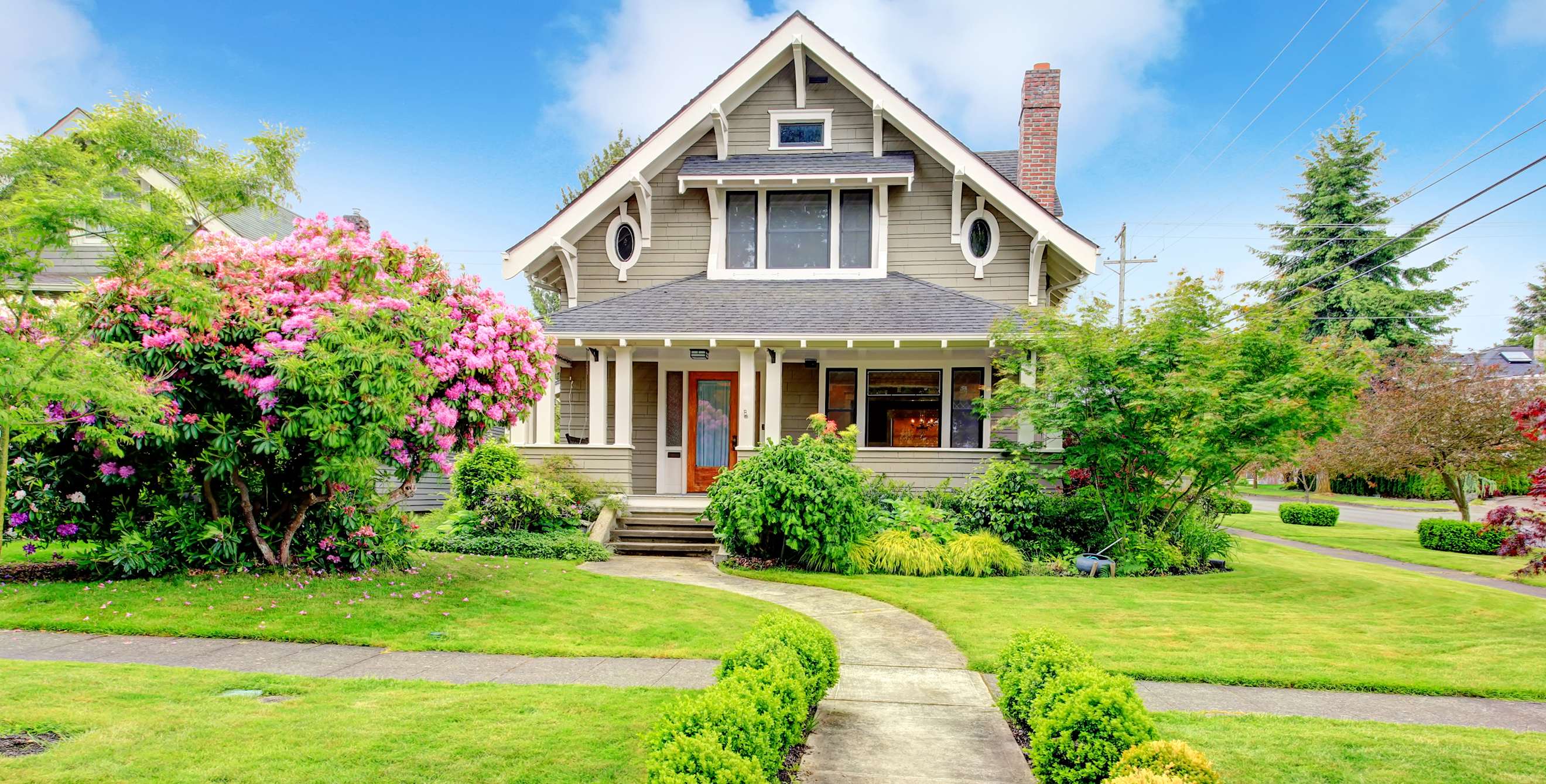 A two story house with a green yard.
