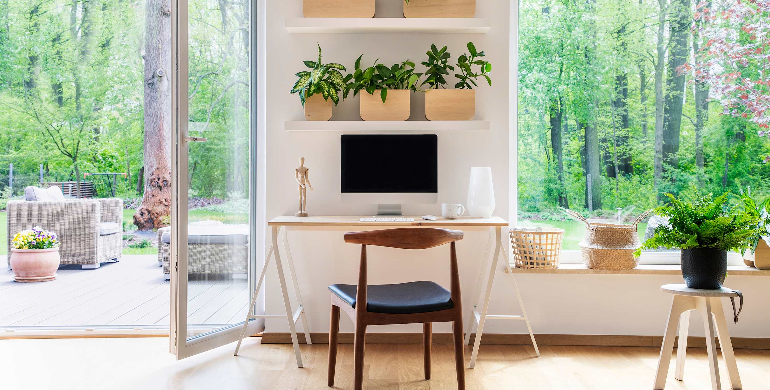 A minimalist home office in the living room next to an open glass door.