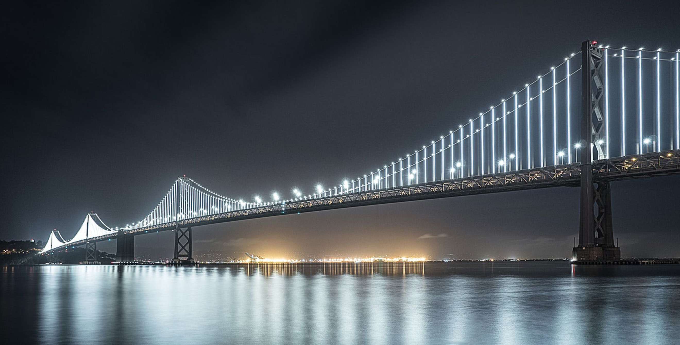 San Francisco Oakland Bay Bridge lit up at night.