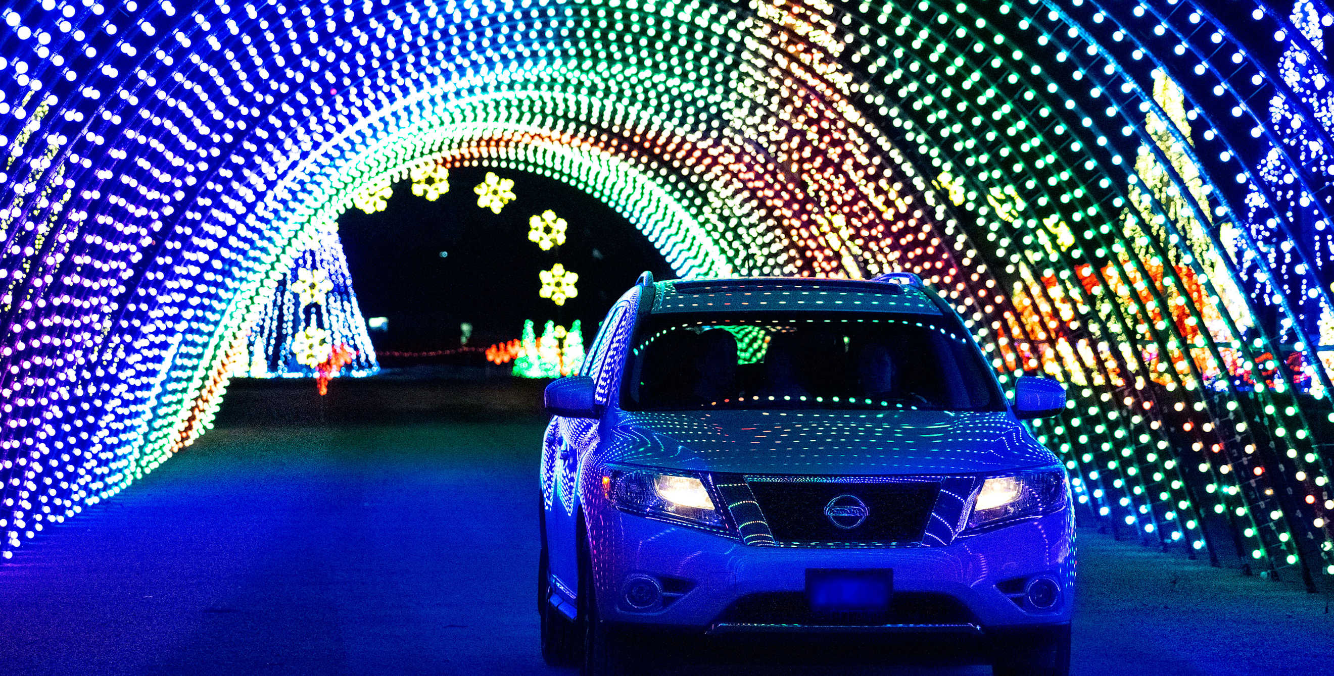 A car drives through a light tunnel at Christmas in Color in Salt Lake City.