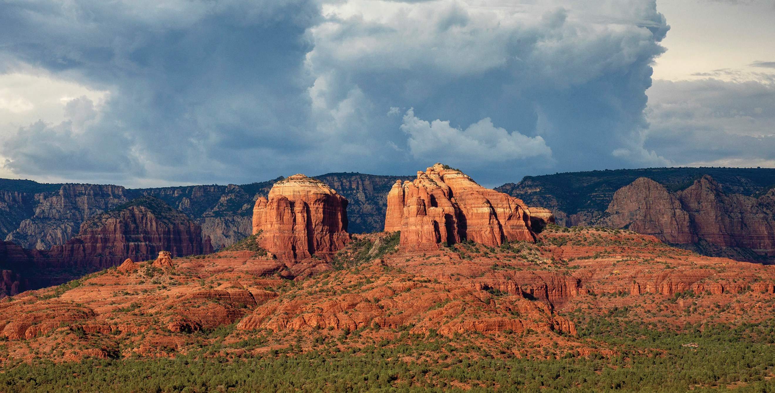 dramatic panorama with rock formations backed by storm clouds at Red Rock State Park in Sadona, Arizona