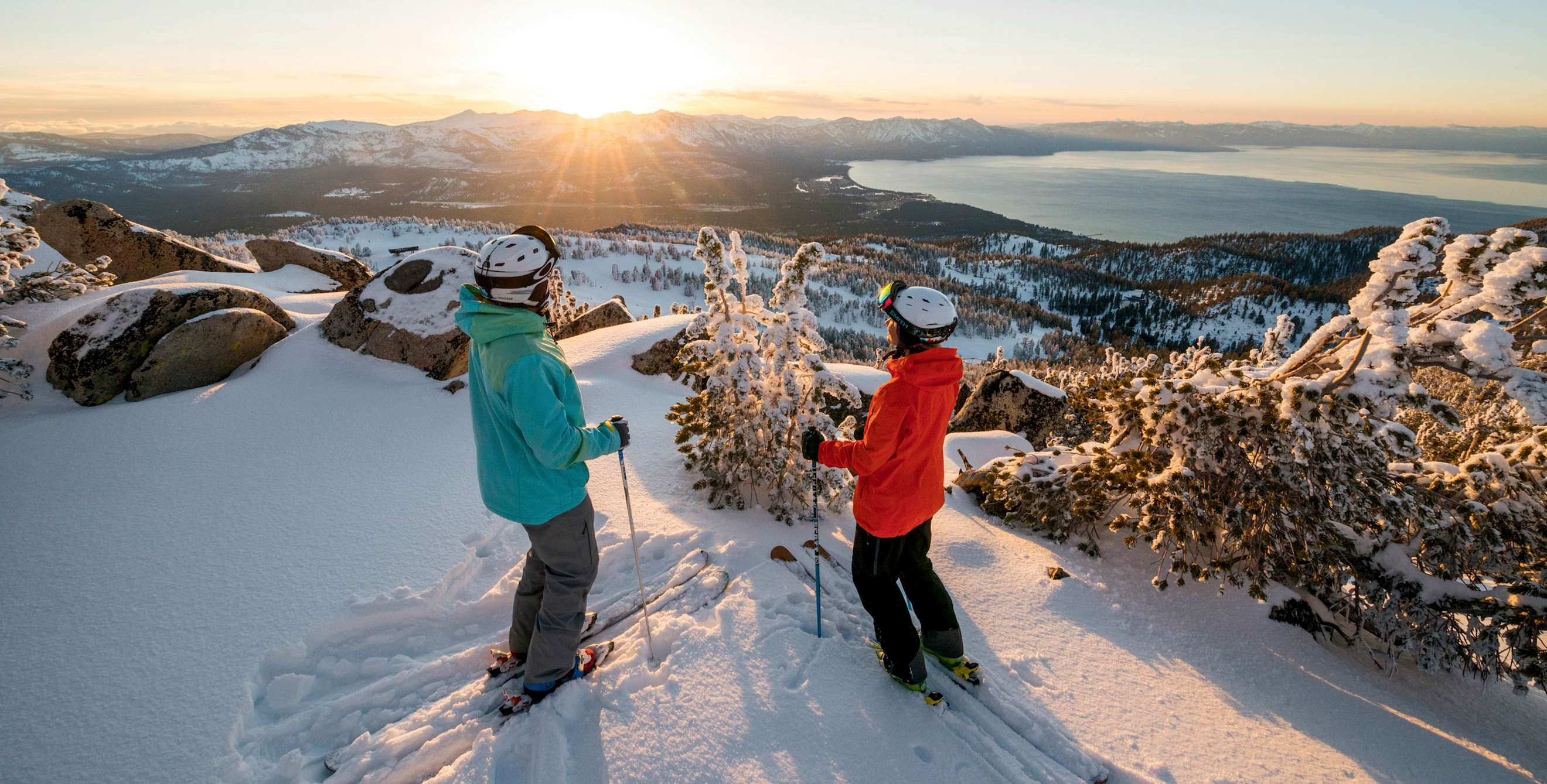 pair of skiers pause for a panoramic view of the winter scenery above Lake Tahoe, California