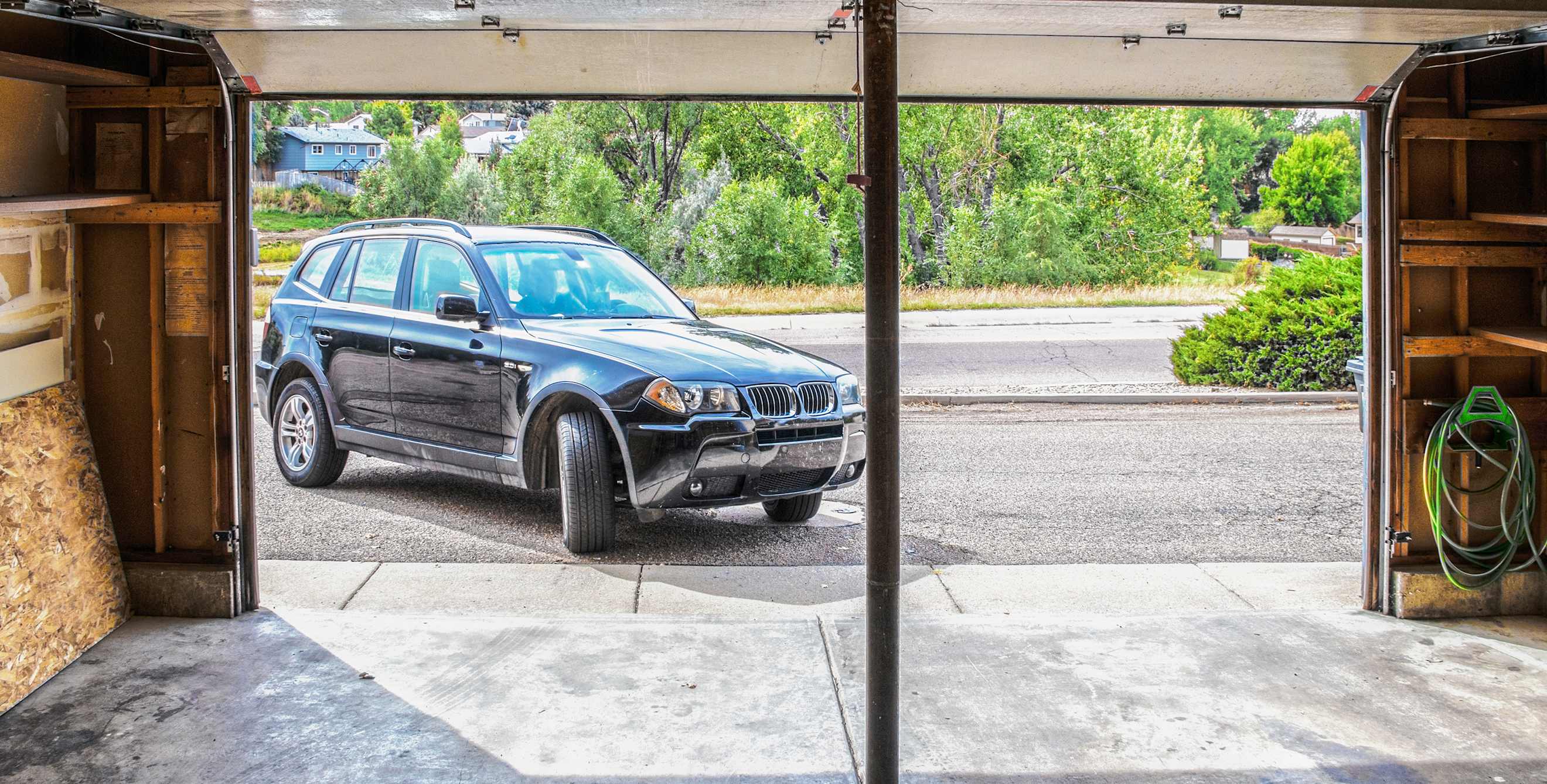 a black SUV pulls into a home garage.