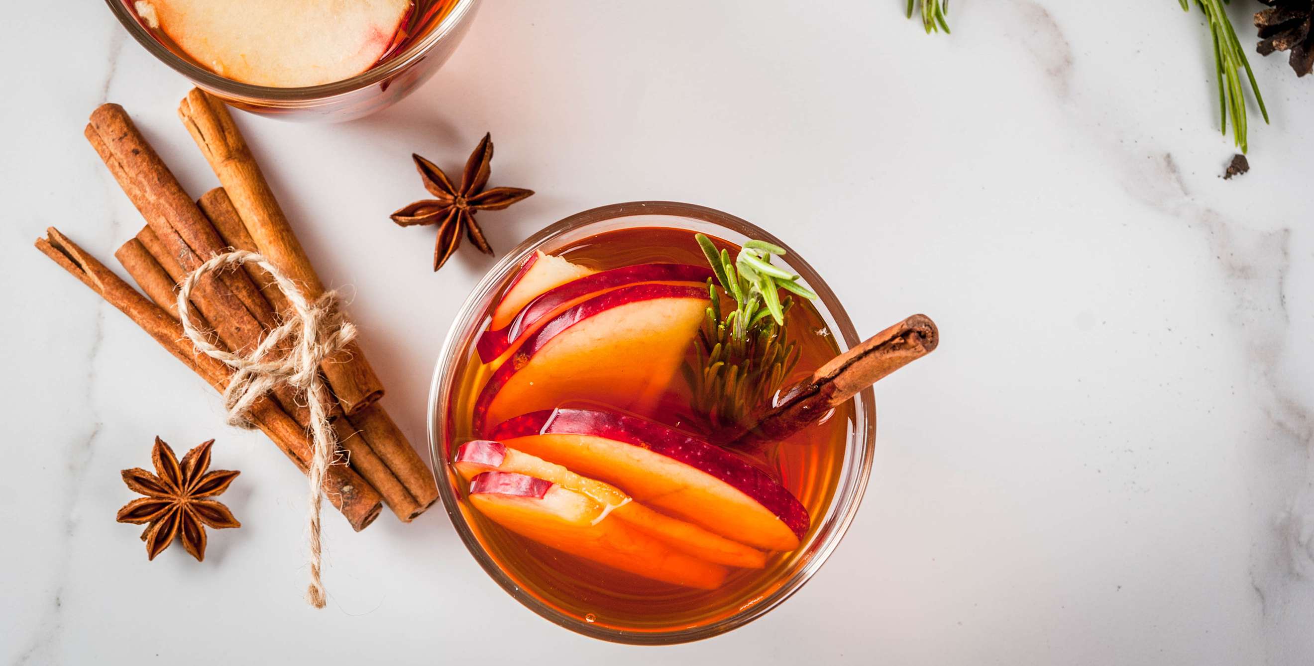 apple cider and spices on a marble table.