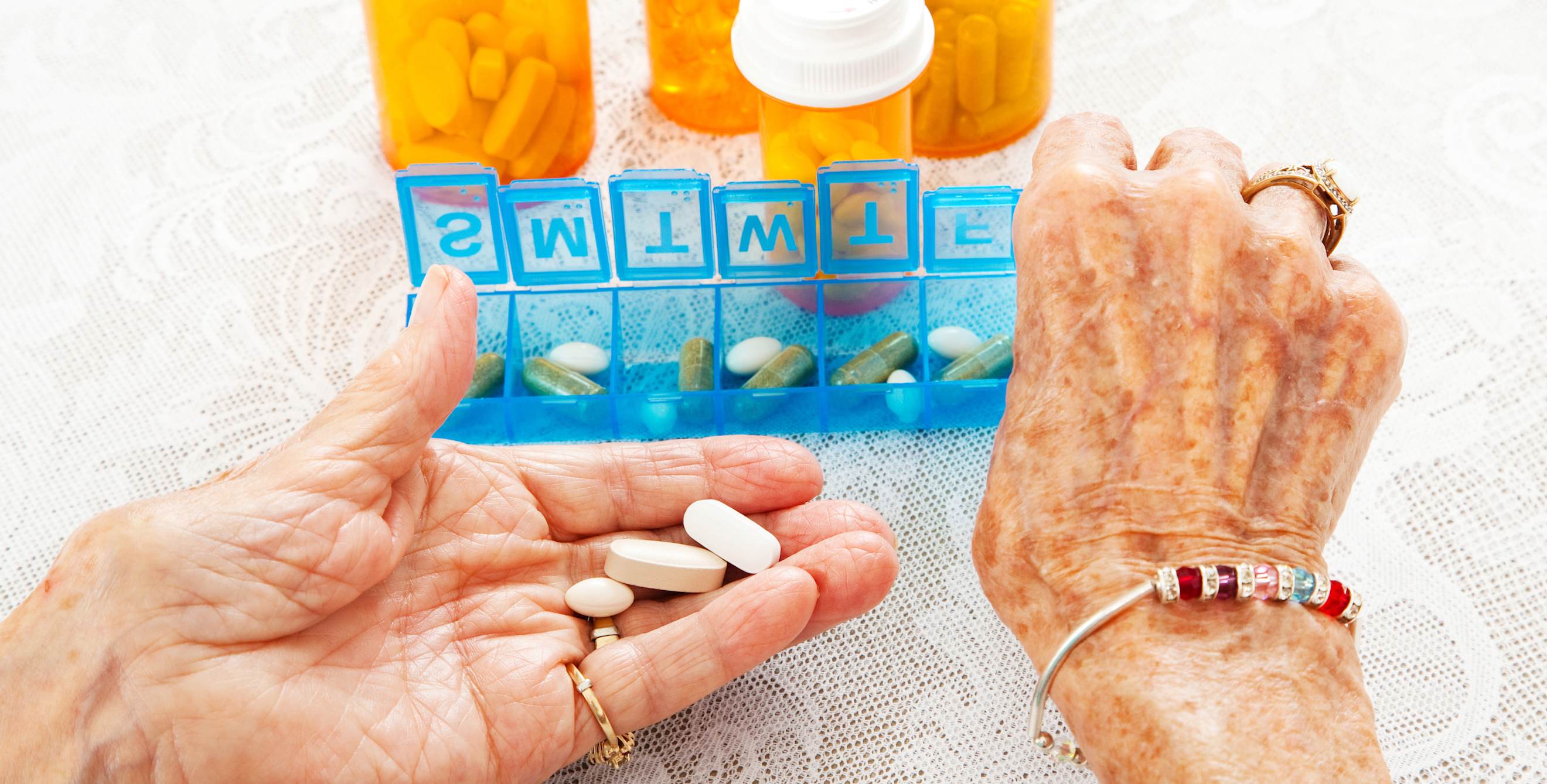 Close up view of elderly woman's hands as she sorts prescription medication