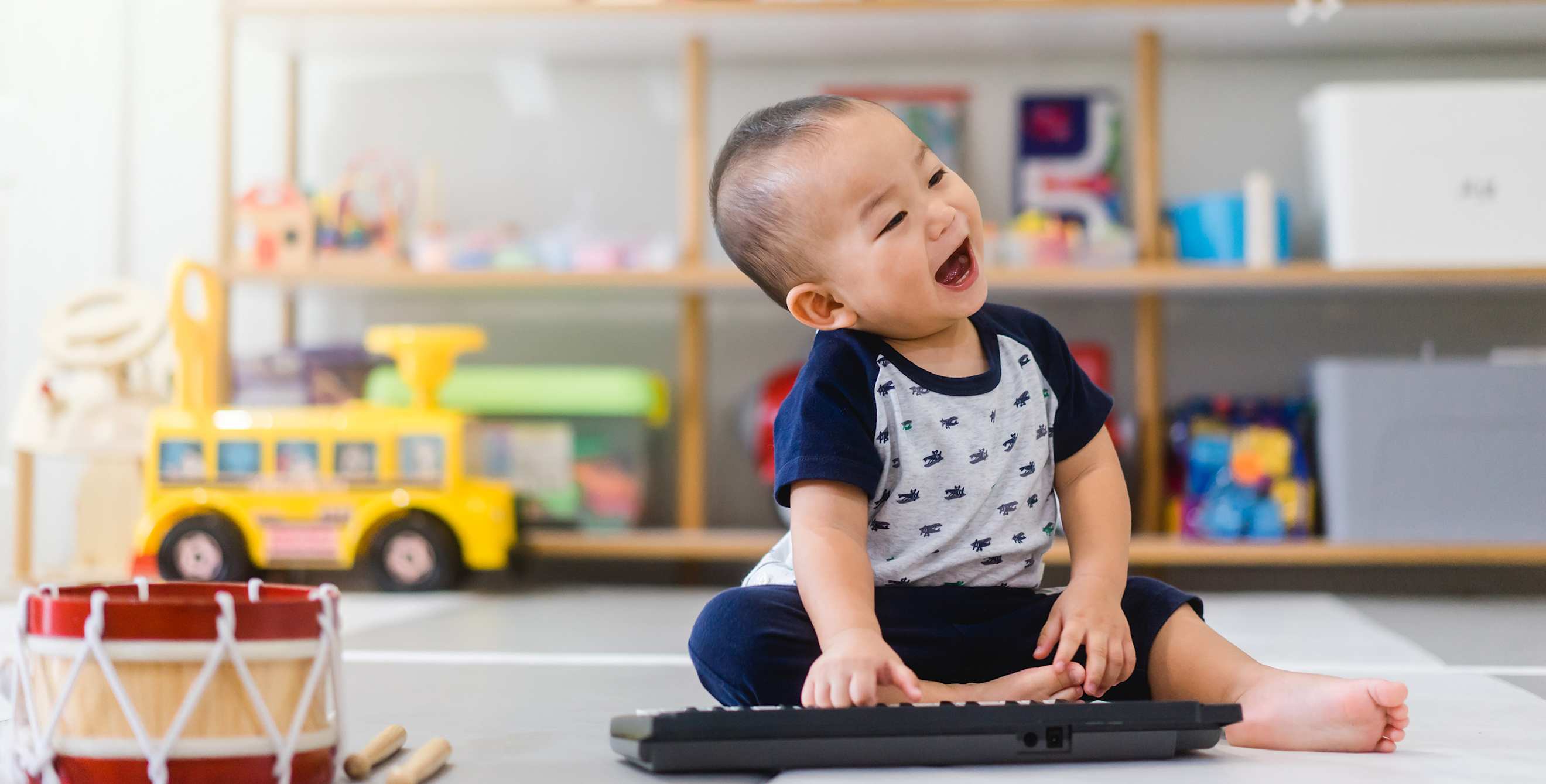 A baby plays with a child keyboard.