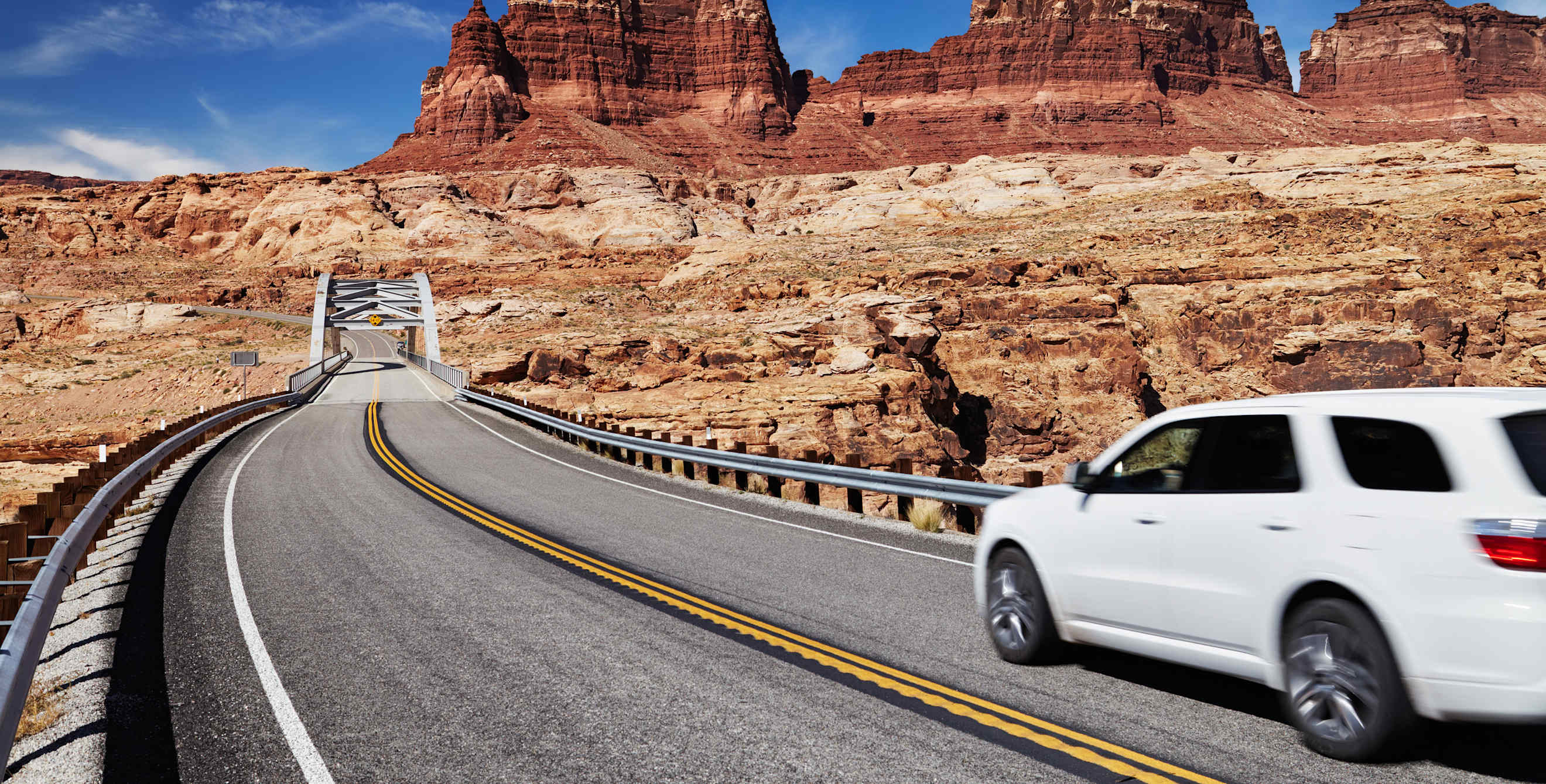 A white SUV drives on a highway in Utah.