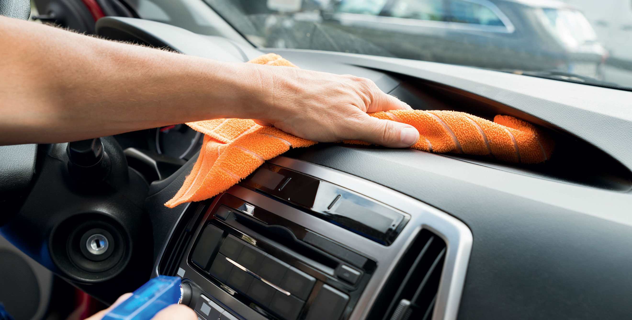 A driver wipes down their dashboard.
