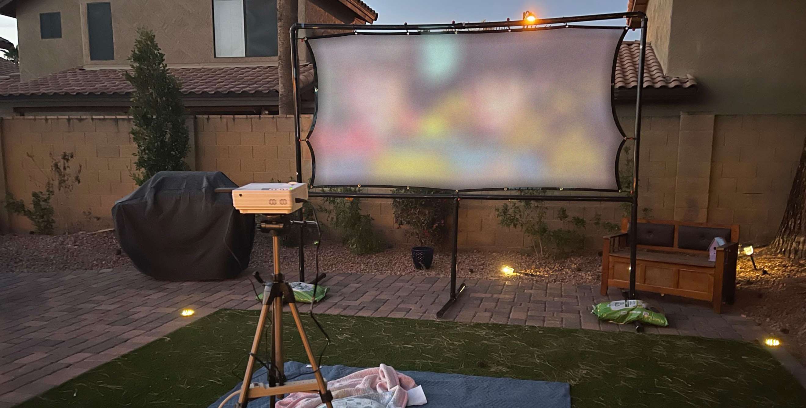 A projector plays a movie on a DIY projector screen.