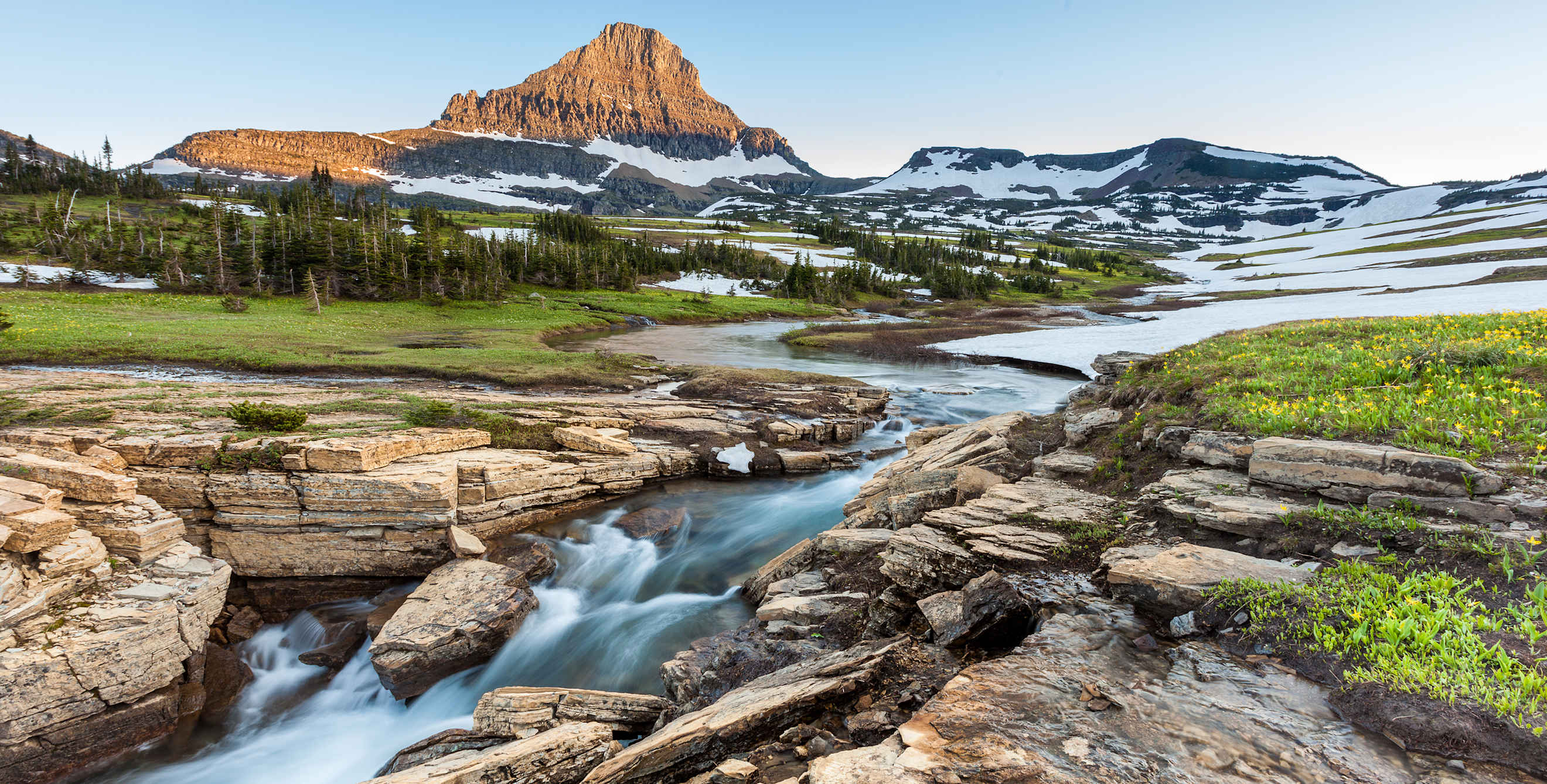 A stream cuts through Logan Pass in Montana's Glacier National Park in early summer.