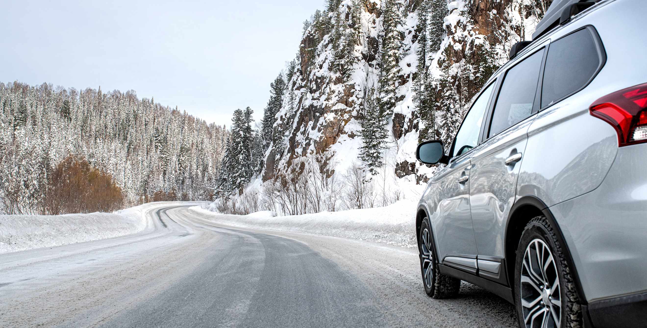 An SUV parked on the side of a snowy road.