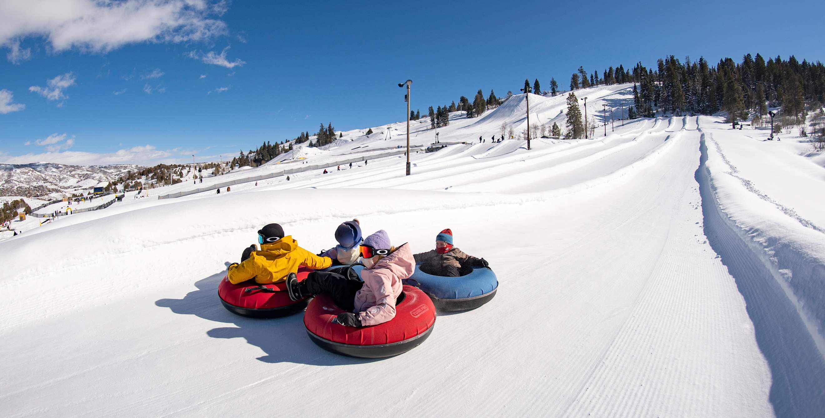 Riders slide down the large tubing hill at Woodward Park City in Utah.