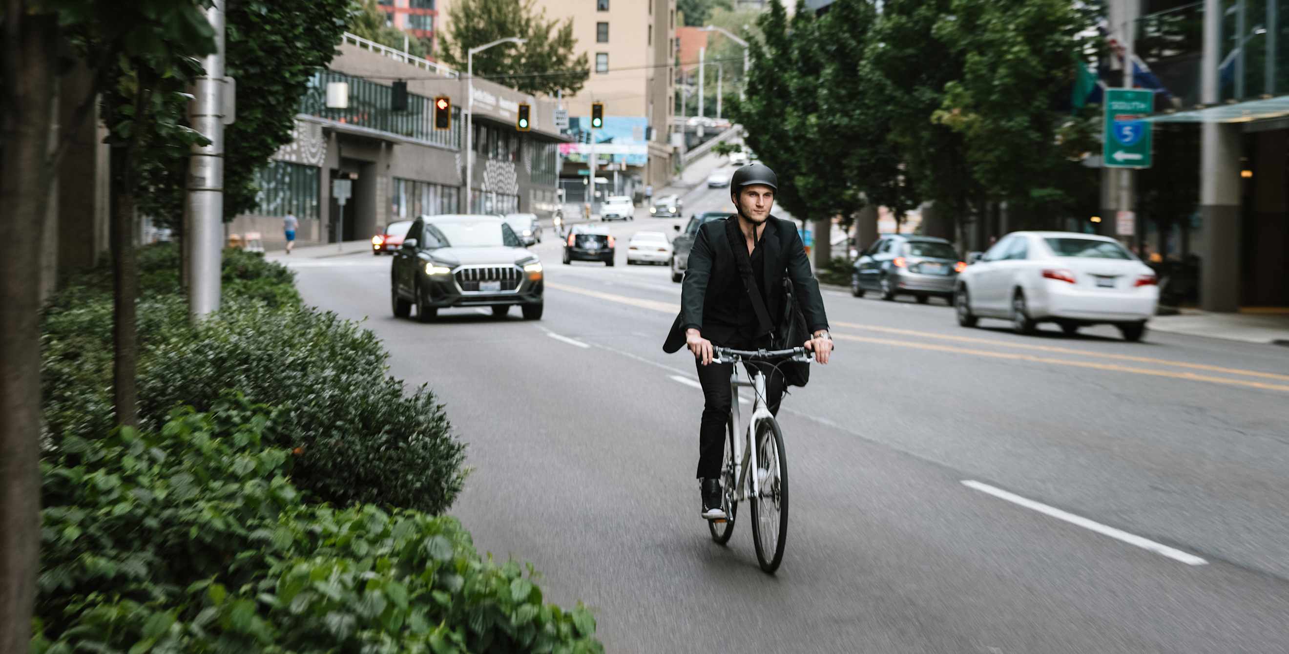 A car safely goes around a cyclist on a city street.