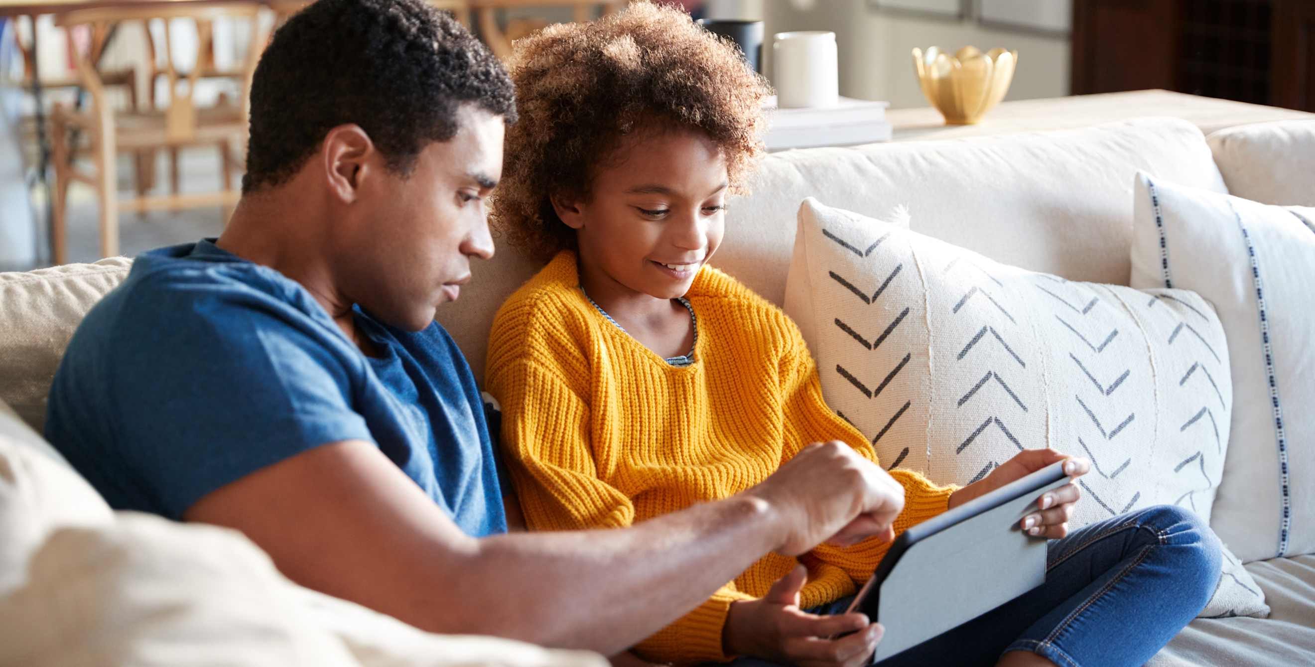 A dad and his child are freezing the child's credit on a tablet.