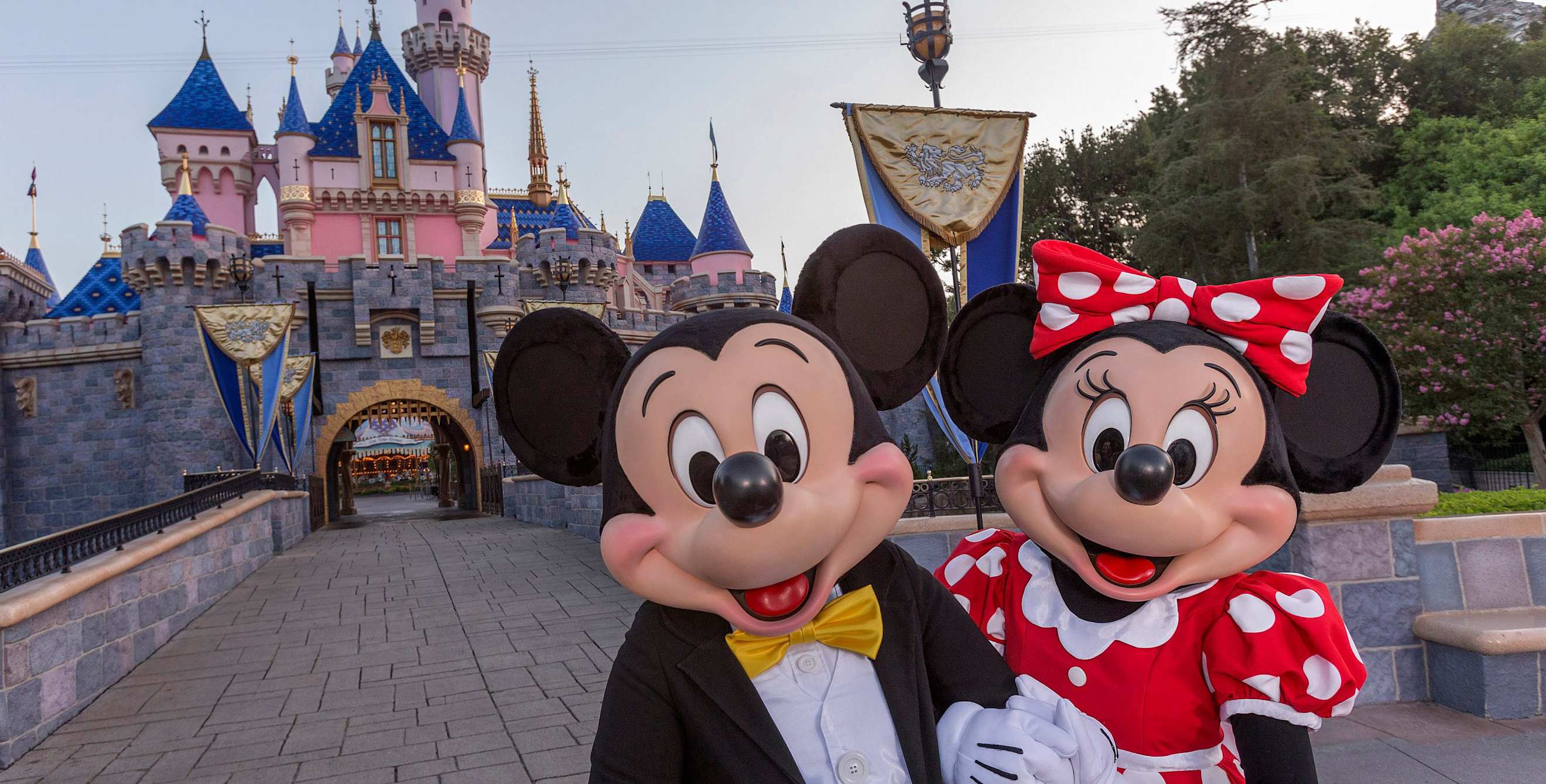 Mickey Mouse stands before Sleeping Beauty's Castle in Disneyland.