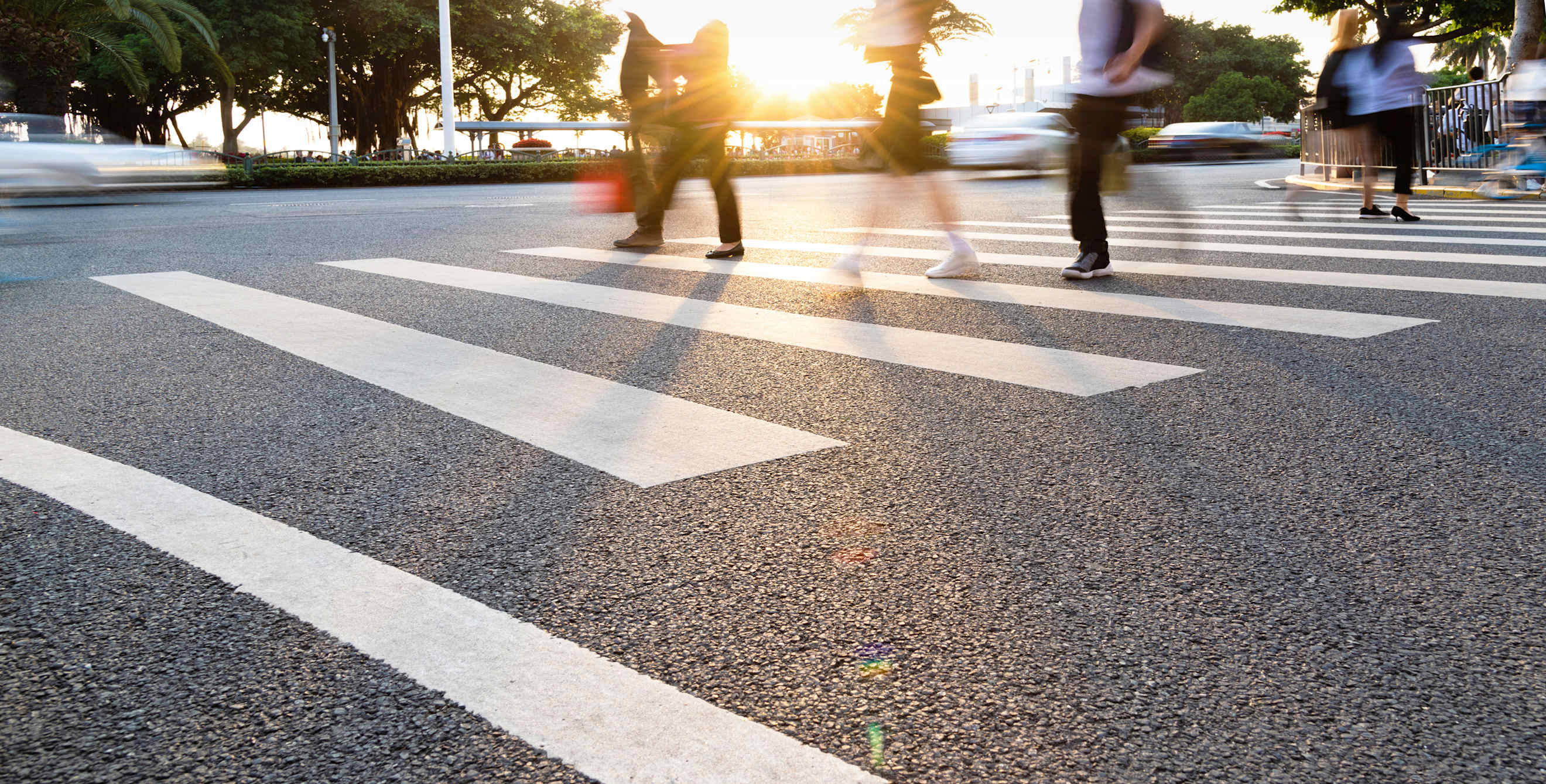 Pedestrians cross the street in a painted crosswalk